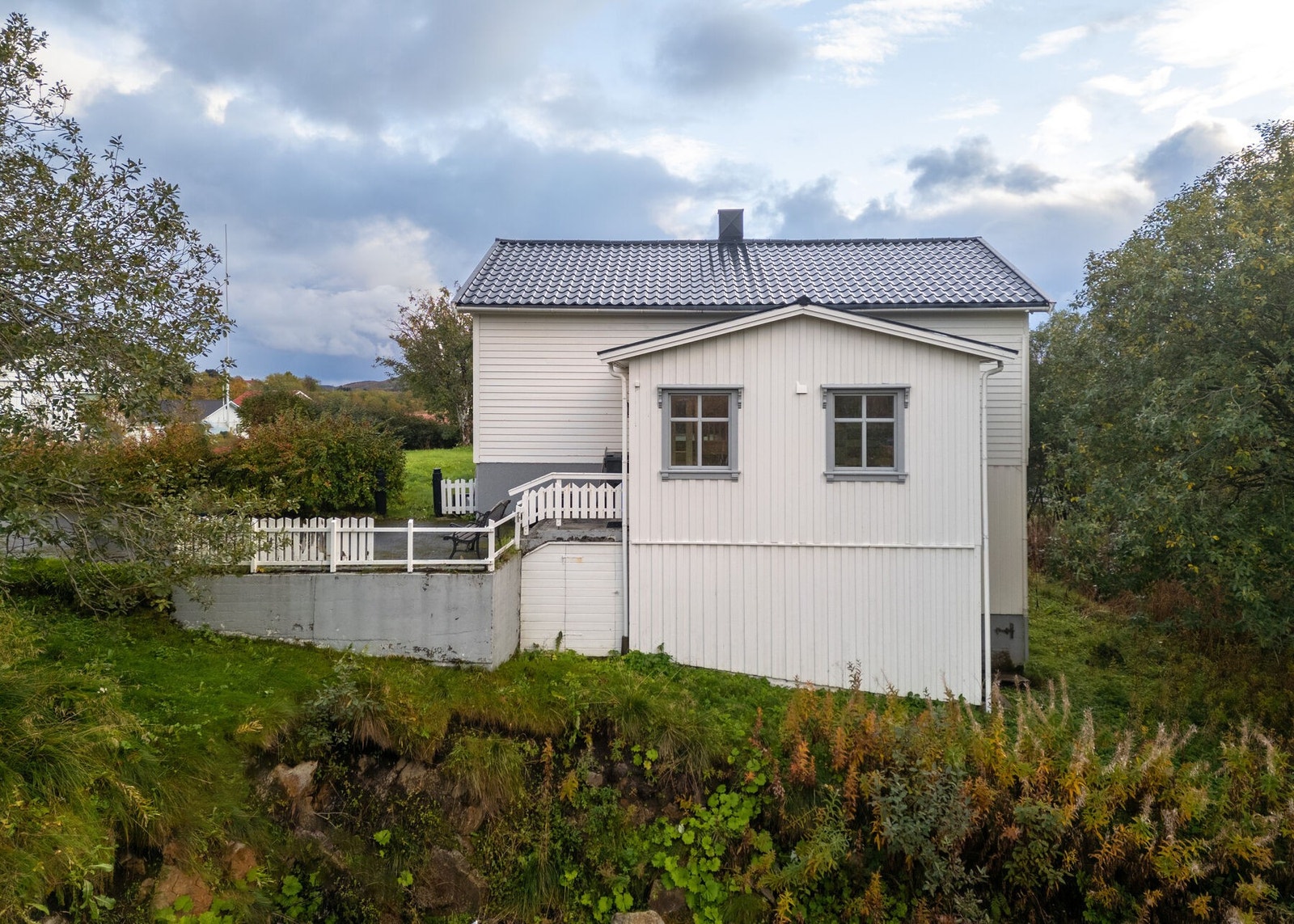 Fasade. Boligen ligger i hellende terreng, på en høyde i terrenget og med noe utsikt. Galleribilde