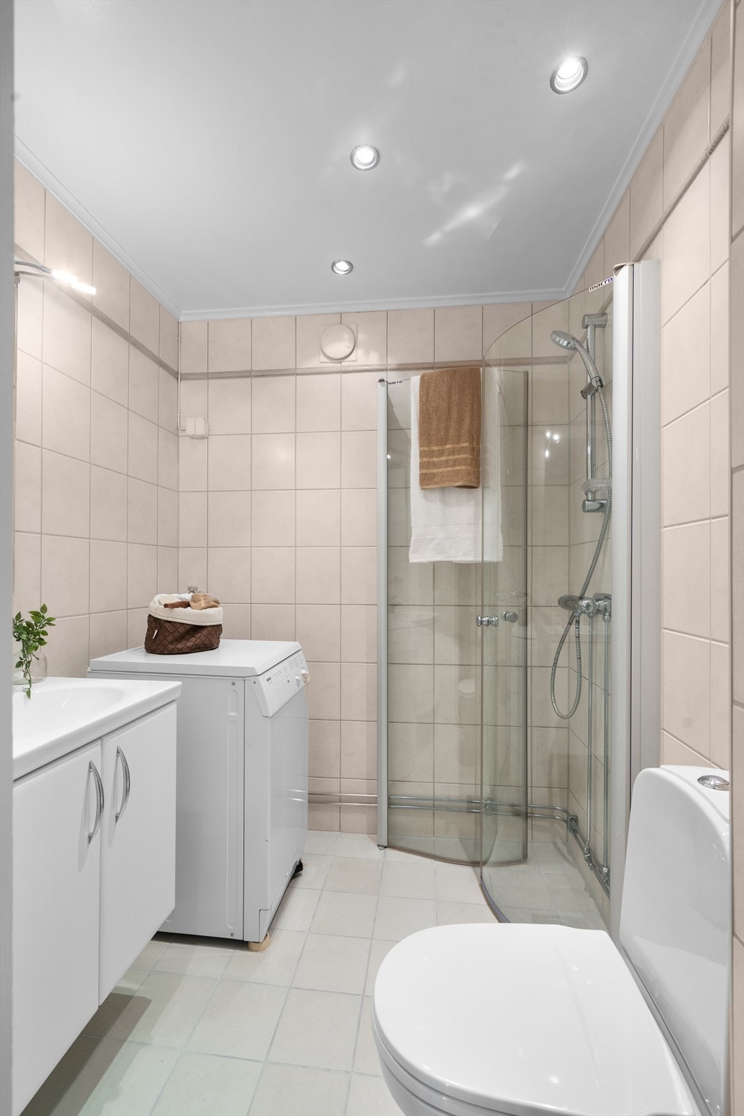 Dusjnisje med innfellbare dører, opplegg for vaskemaskin og spotter i taket Galleribilde