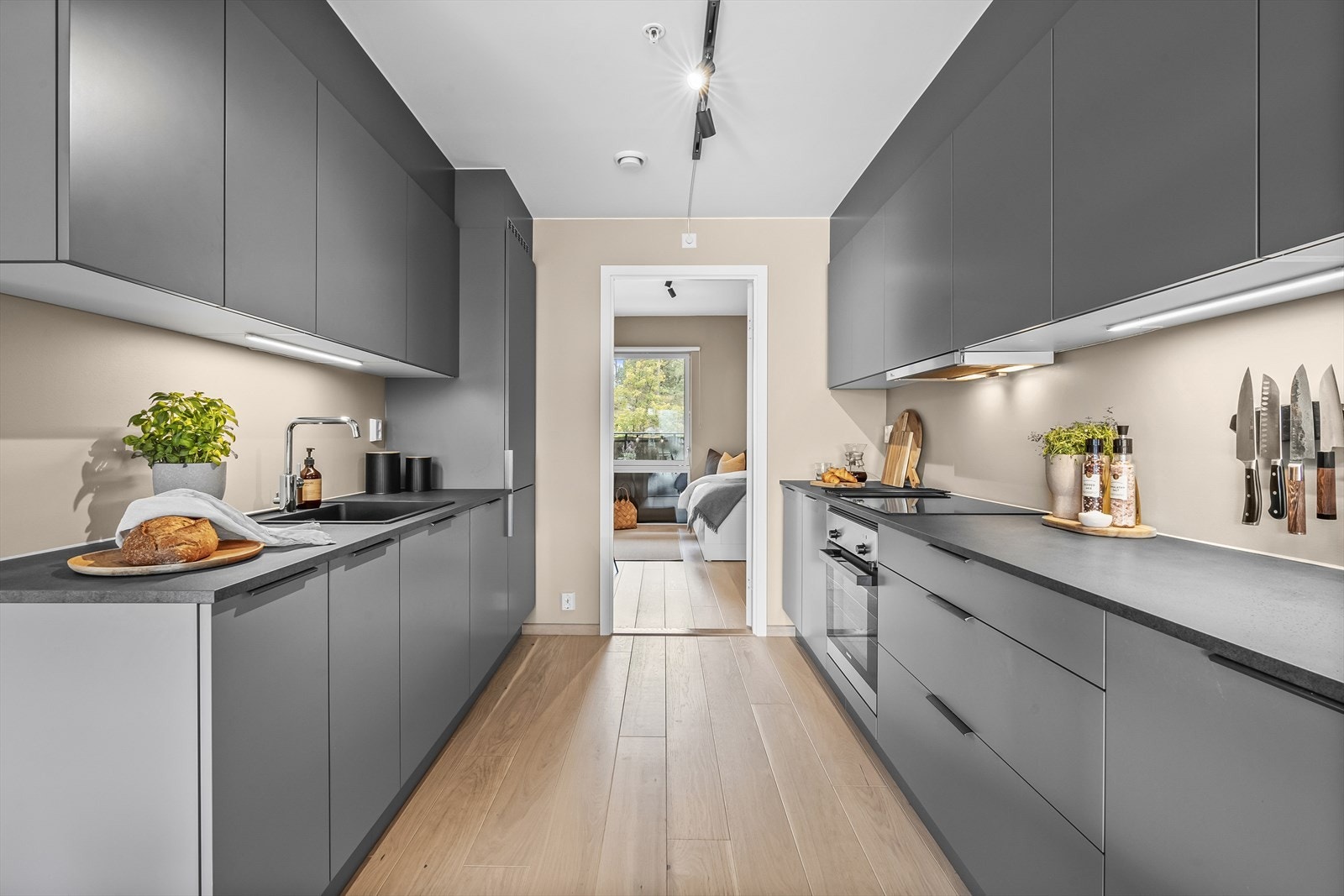 Det er belysning over benkeplaten og laminat benkeplate med nedfelt vaskekum. Galleribilde