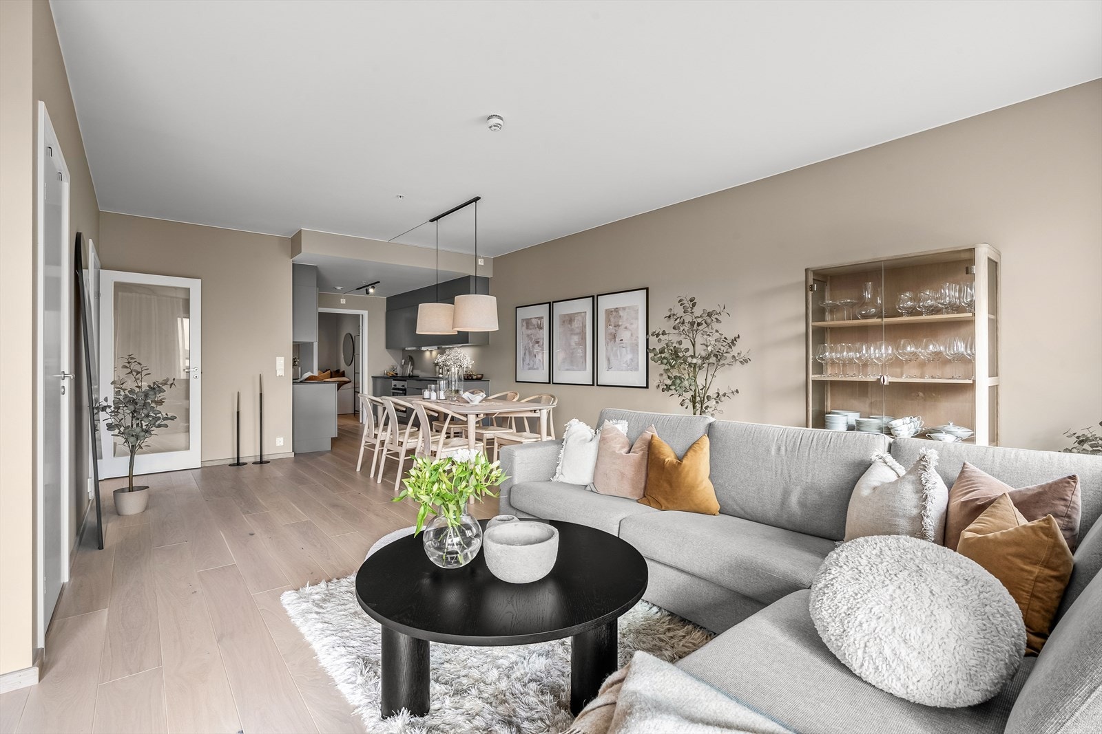 Et sosialt rom med kjøkken i åpen løsning mot stuen. Galleribilde