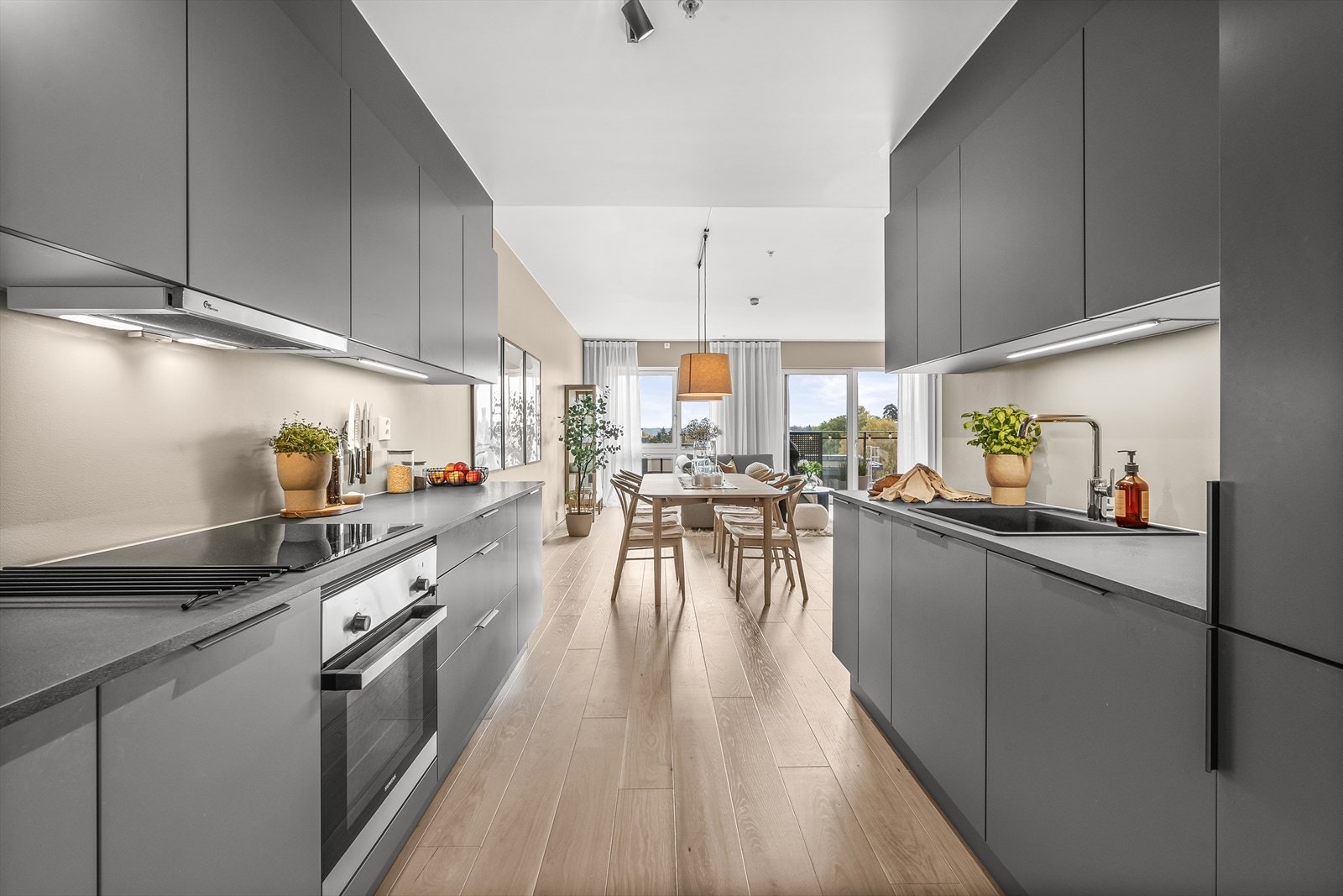 En stilren HTH kjøkkeninnredning med glatte fronter og godt med skap- og benkeplass. Galleribilde