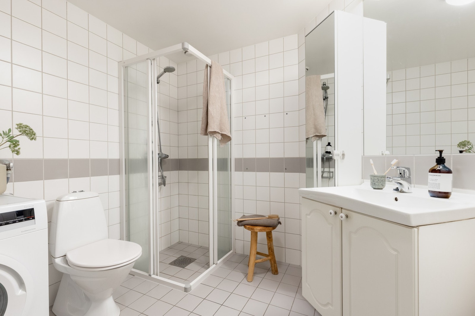 Boligen har et lyst flislagt baderom med varme i gulv. Rommet har opplegg for vaskemaskin. Galleribilde