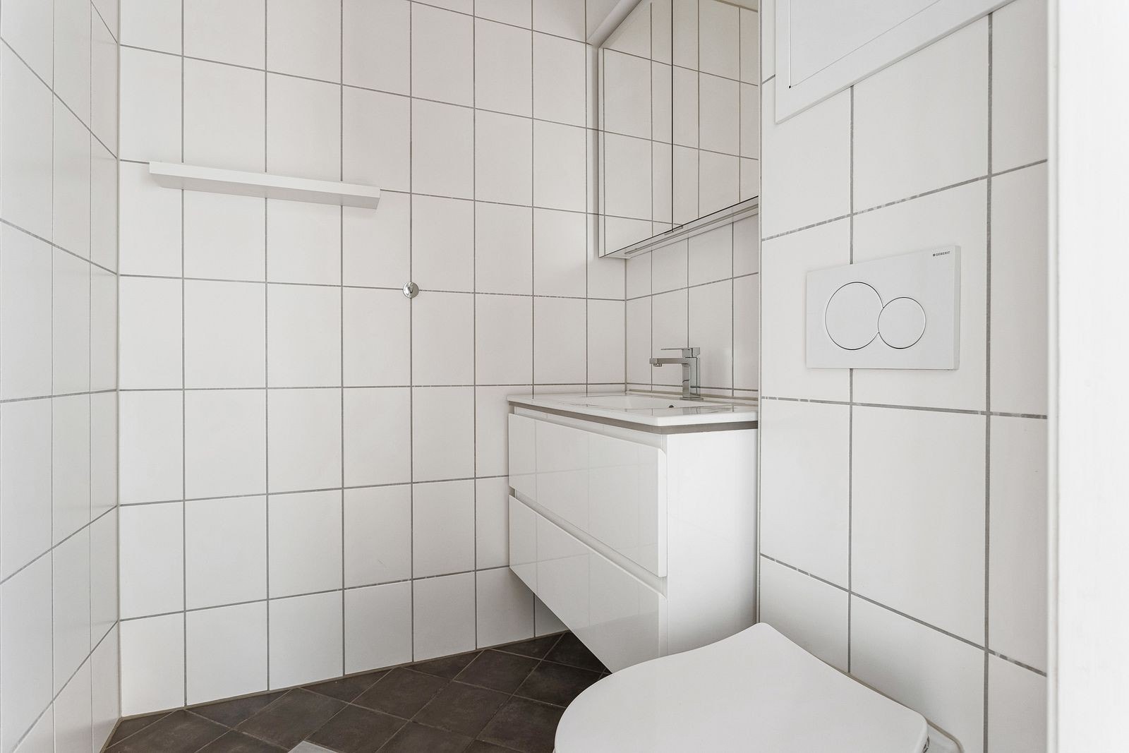 Separat toalettrom med moderne innredning og vegghengt toalett. Galleribilde