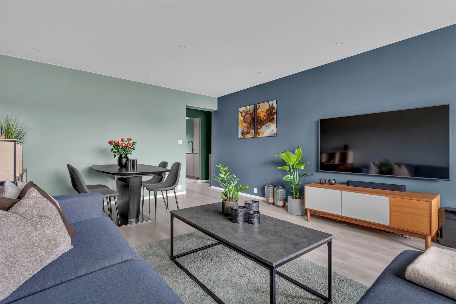 Stuen har praktisk inndeling i to soner - en hyggelig sofakrok med plass til TV, og en spiseplass for måltider. Galleribilde