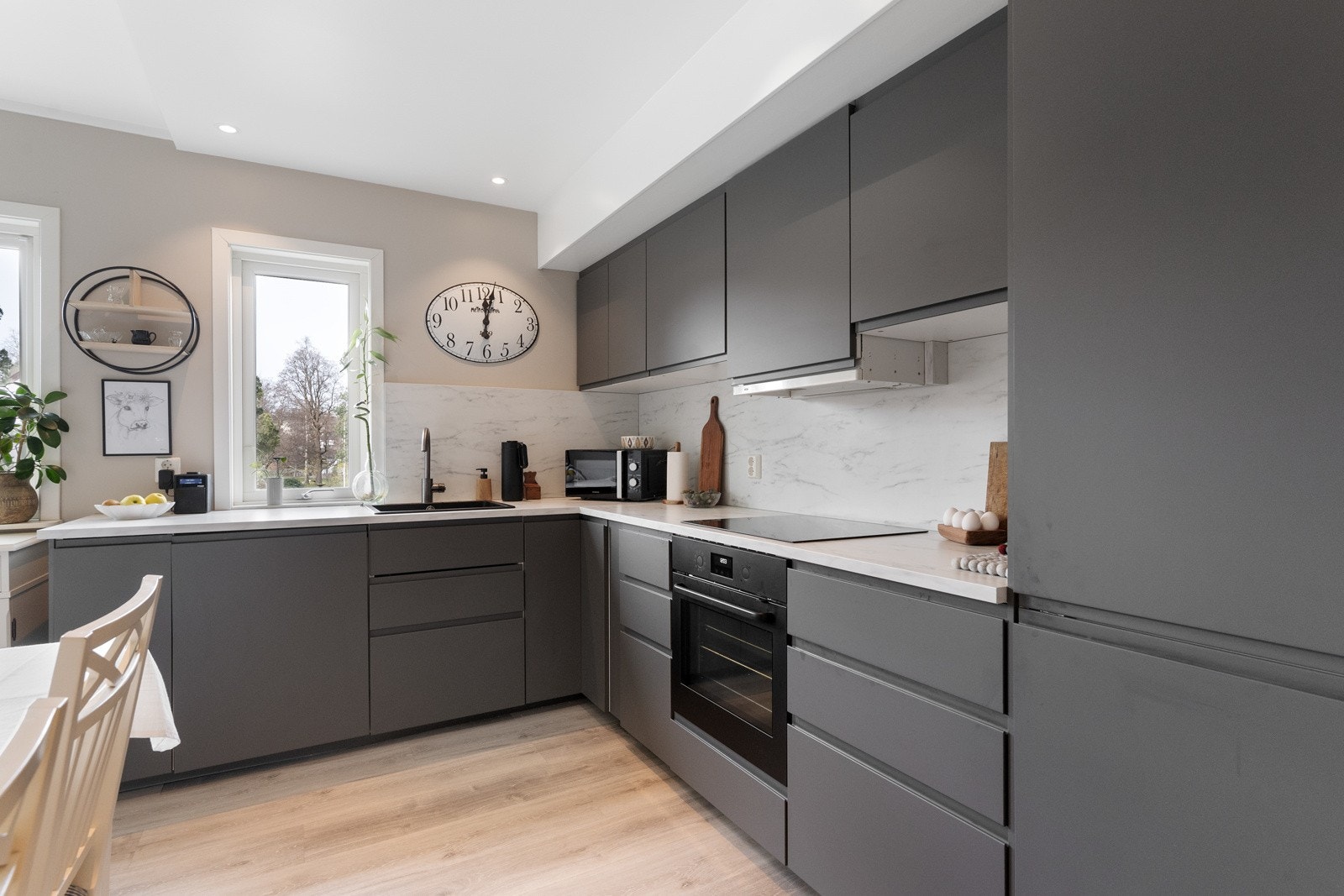 Kjøkkeninnredning med laminerte skrog og glatte fronter. Laminert benkeplate med kjøkkenkum. Galleribilde