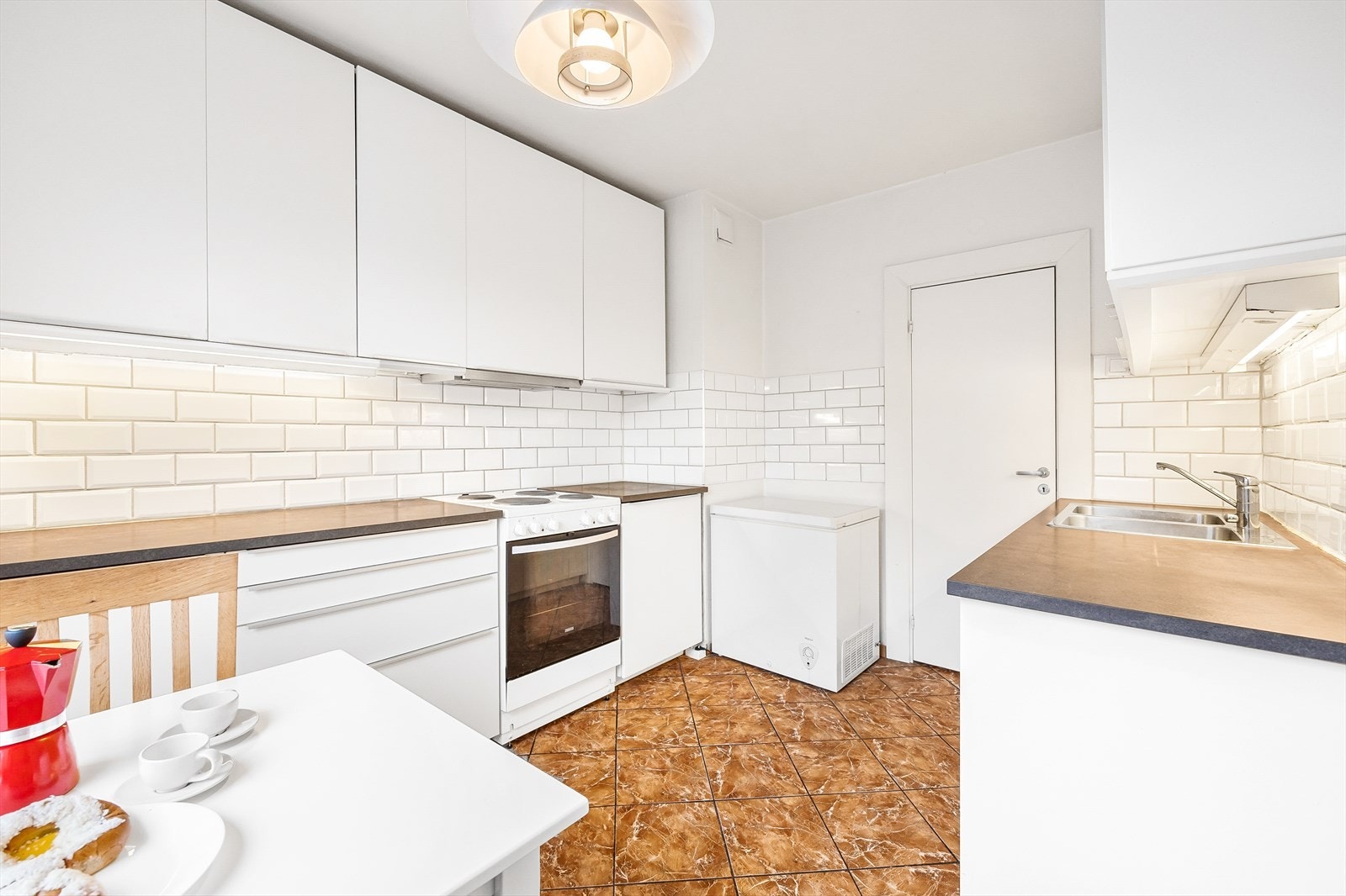 Hvite subway-fliser pryder og beskytter bakveggene og ventilatoren har kullfilter. Galleribilde