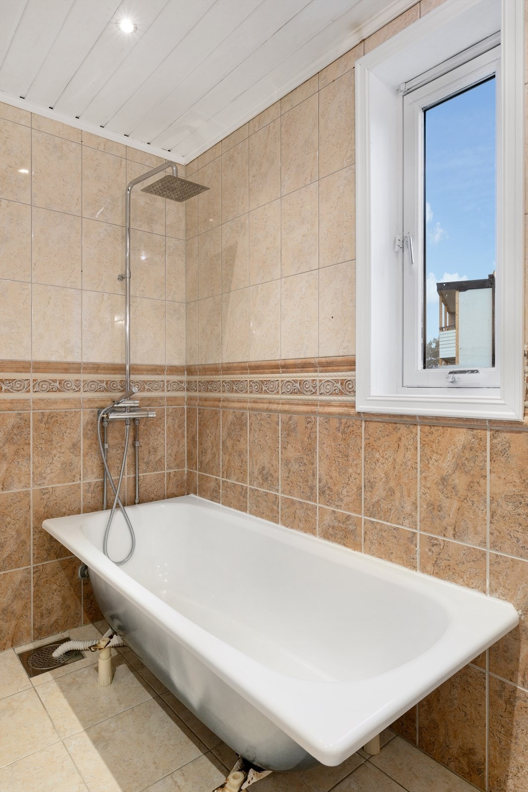 Badekar med dusjløsning og naturlig lys fra vinduet Galleribilde