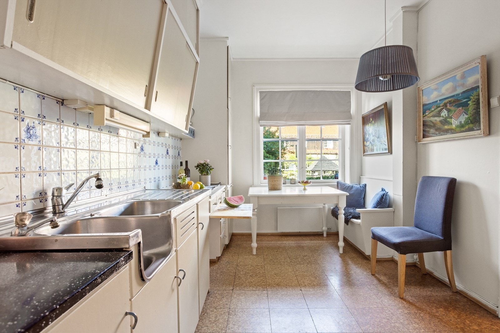 Innredningen består av laminat benkeplate, fliser over benk og rustfritt benkeslag med to kummer. Det er en hyggelig sitteplass ved vinduet. Galleribilde