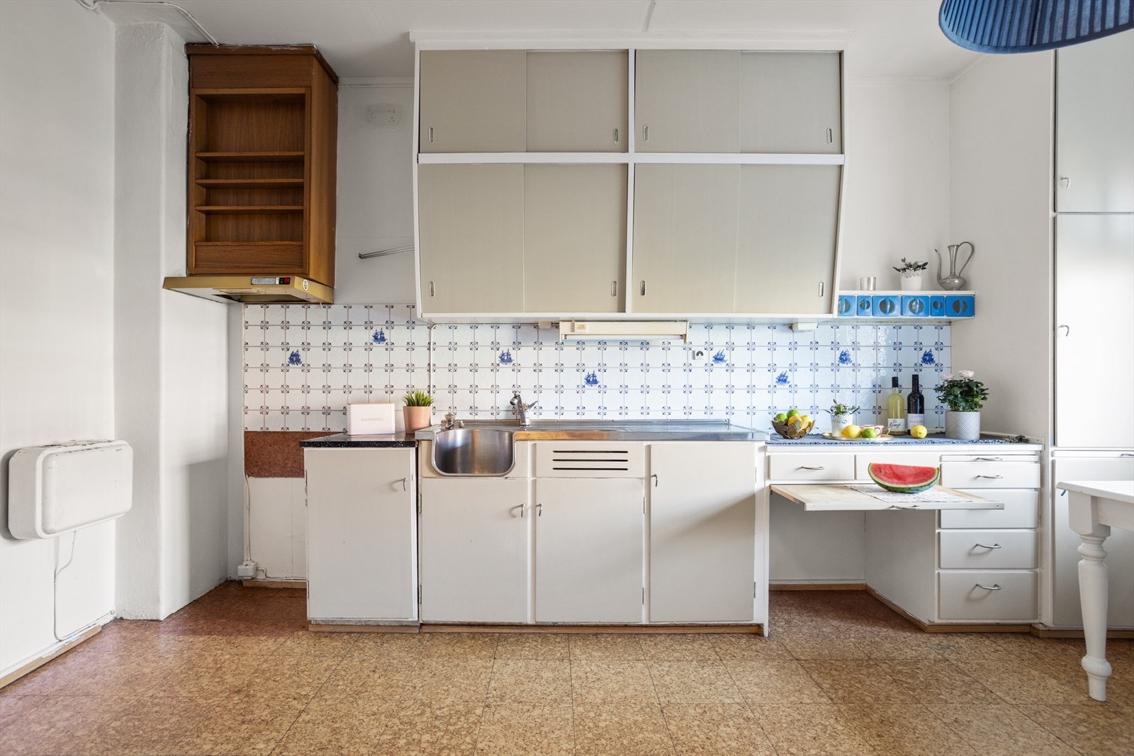 Kjøkkenet ligger i en separat løsning fra resten av stuen, og har en malt original innredning. Galleribilde