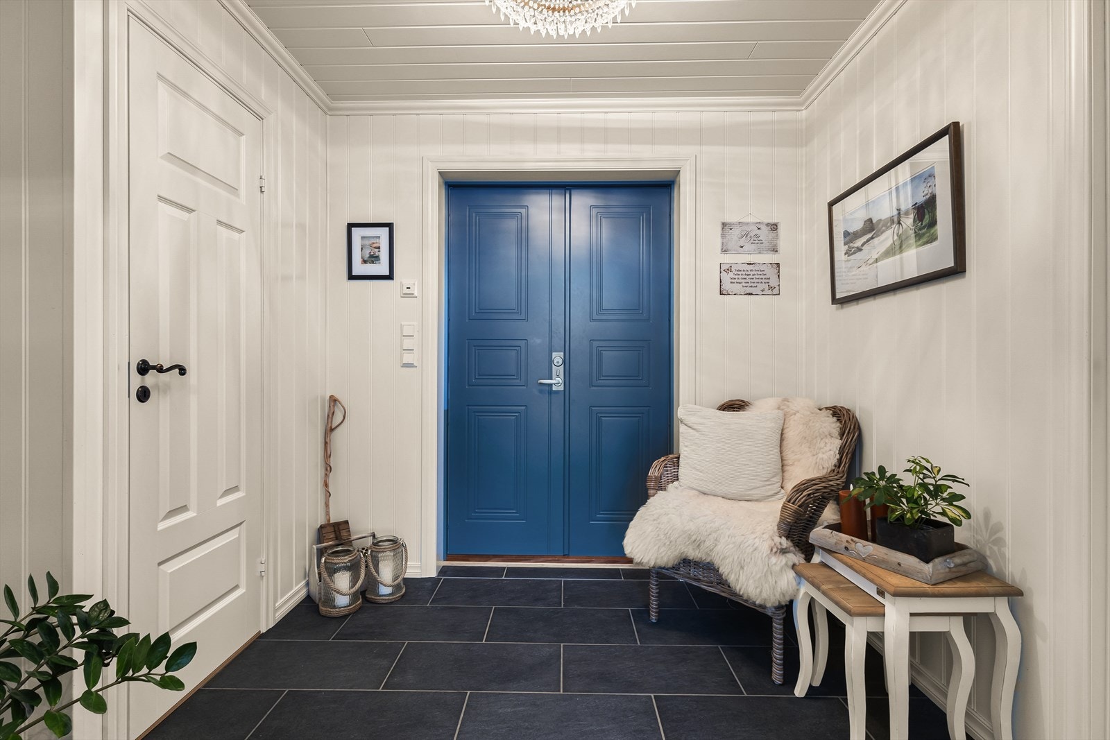 Entréen har flislagt gulv og rommer ulike oppbevaringsløsninger for yttertøy og sko. Galleribilde