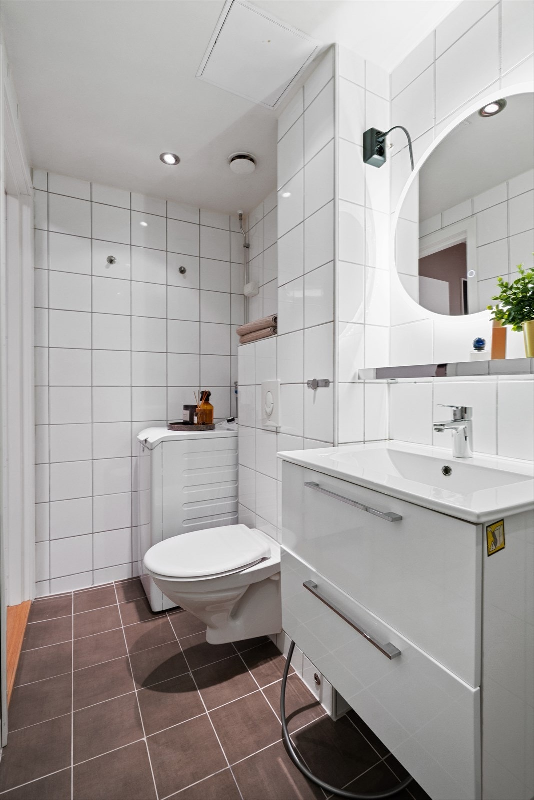 Flislagt bad med elektrisk gulvvarme og opplegg for vaskemaskin. Galleribilde