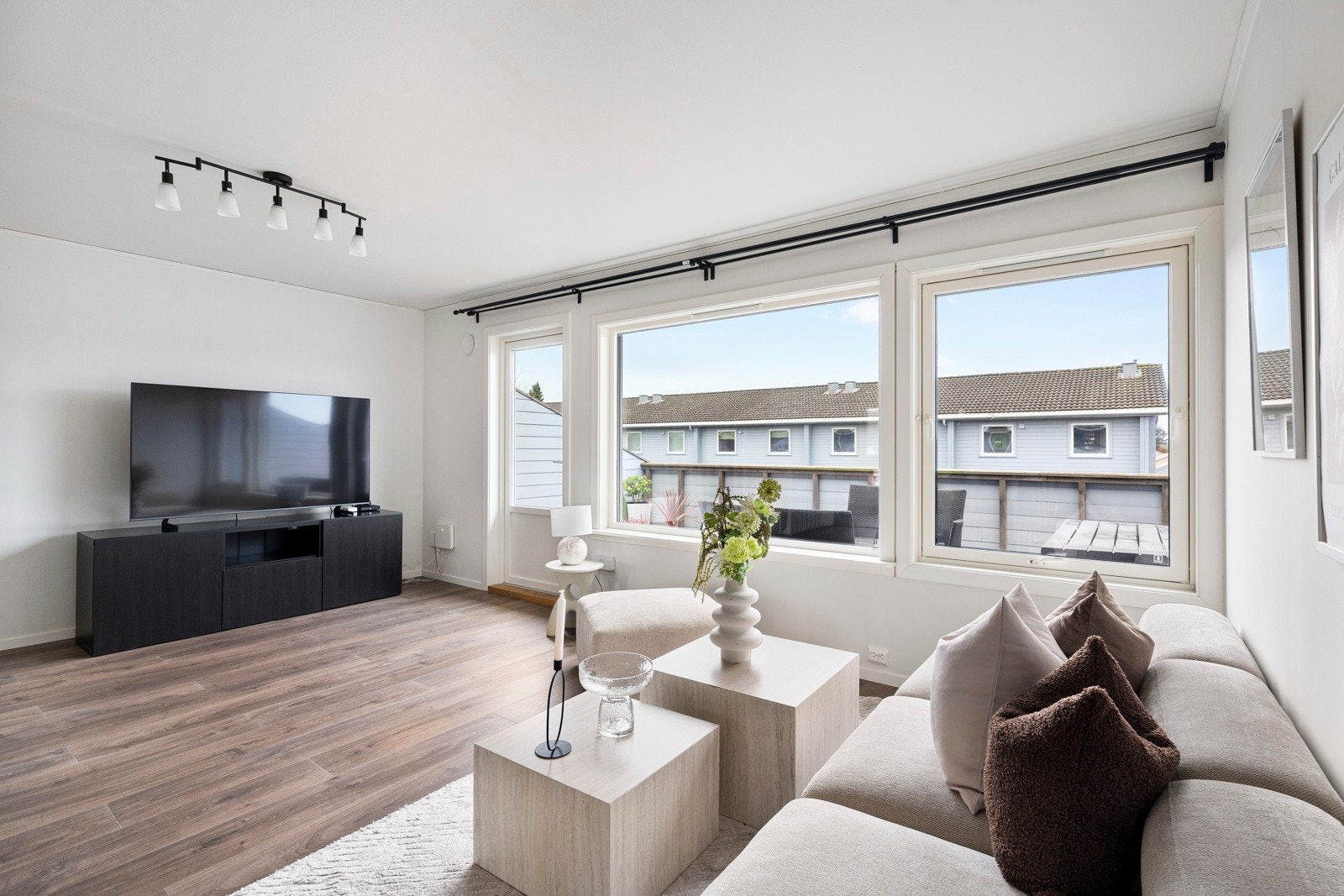 Det naturlige lyset gjenspeiles fint i de lysmalte overflatene, stuen har også et mørkt laminatgulv. Galleribilde