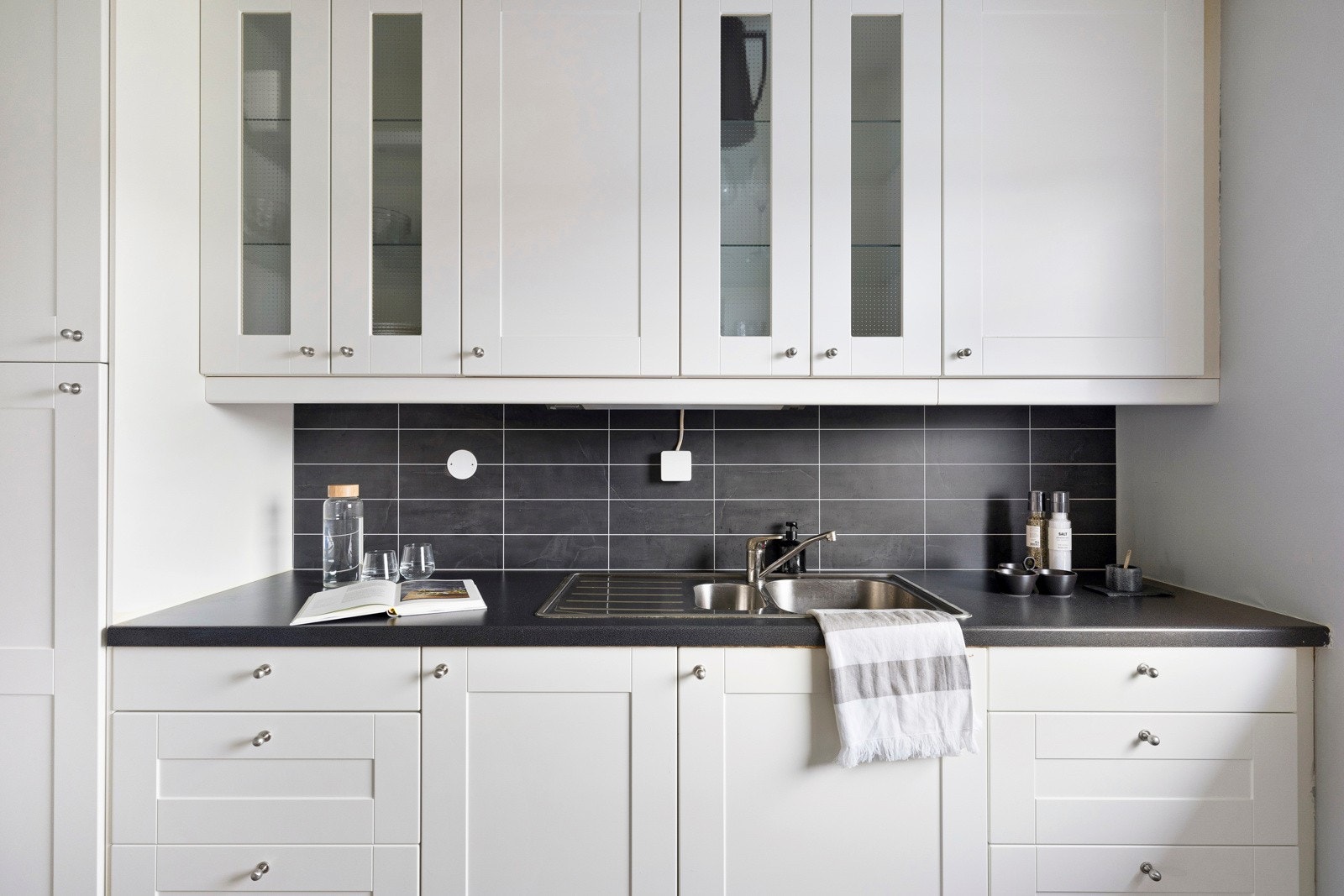 Bak benkeplatene er det en delikat mørk flis, som gjør det enkelt å holde kjøkkenet rent. Galleribilde