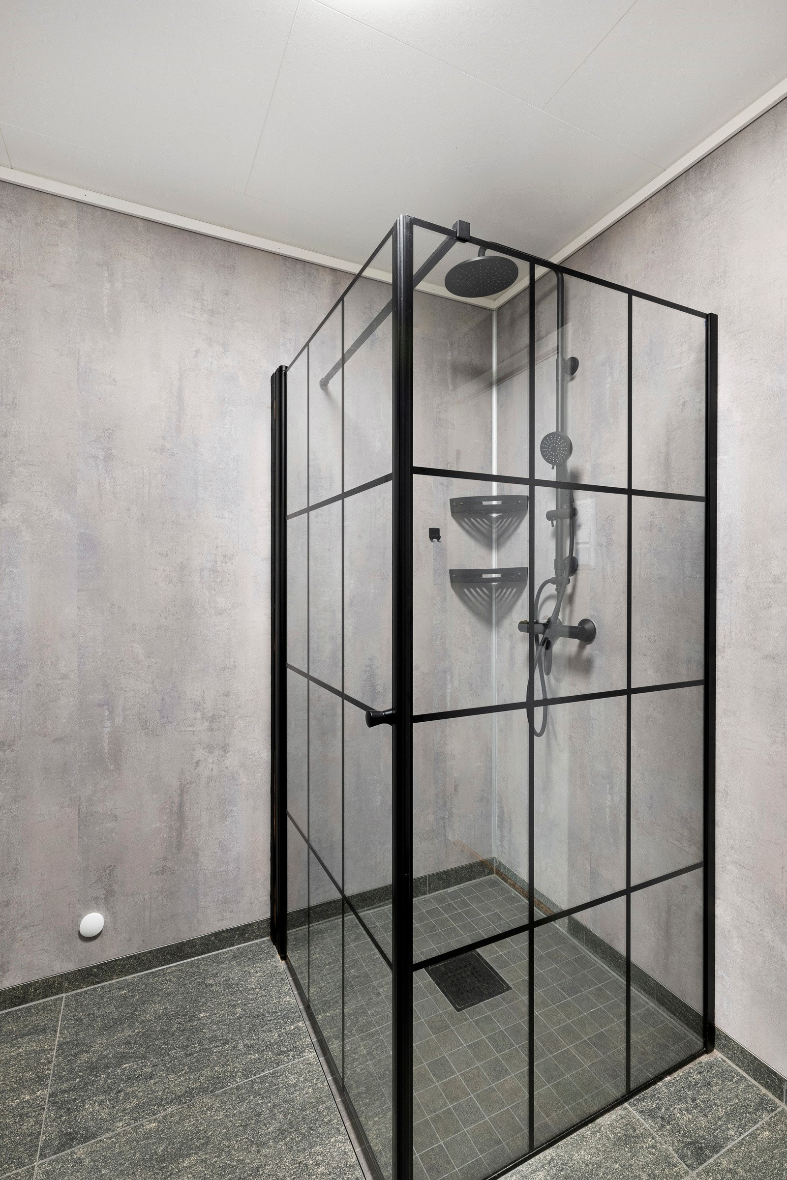 Badet har et stort dusjhjørne med svarte rammer som gir et moderne preg. Galleribilde