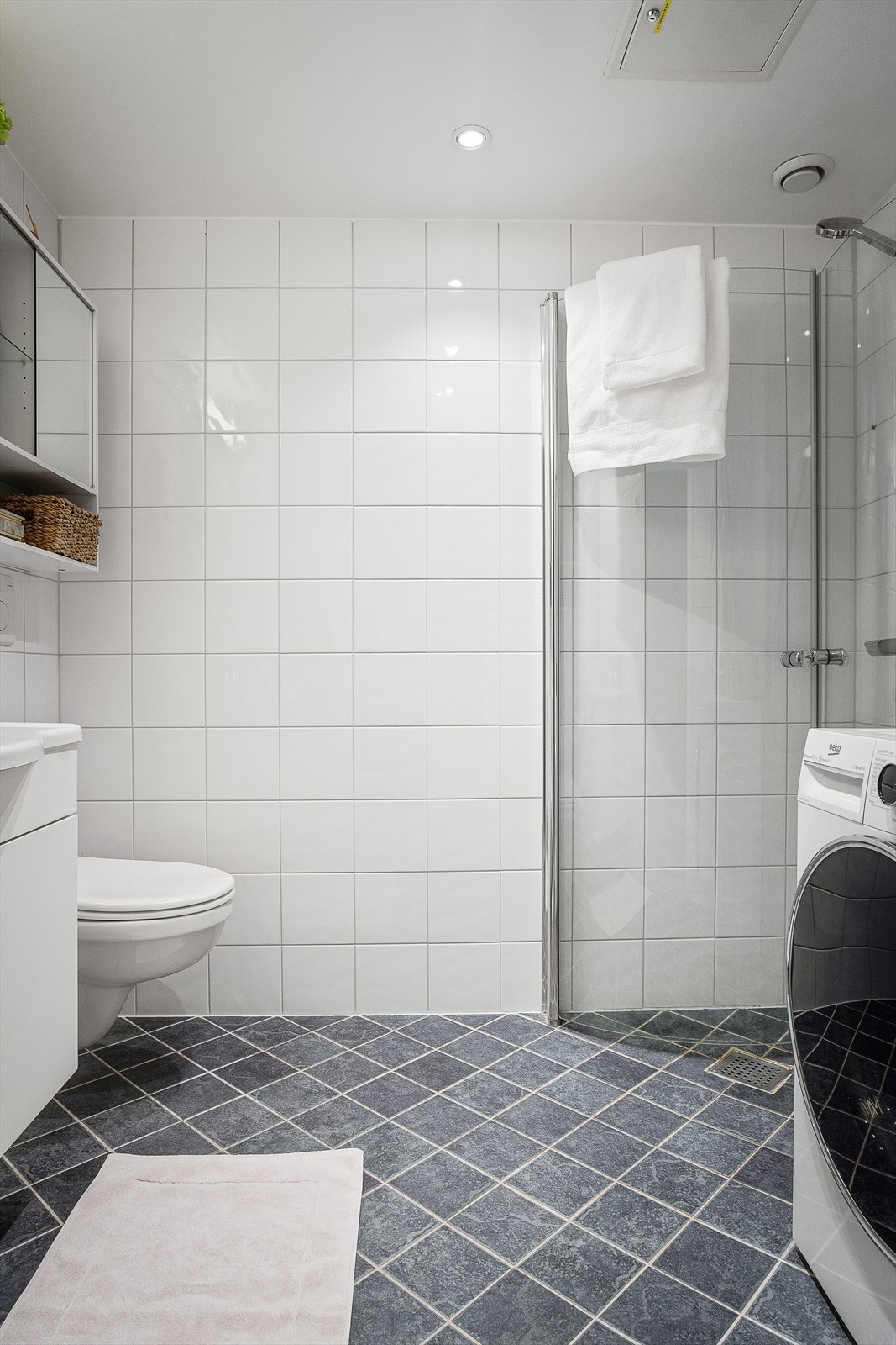 Det er veggmontert toalett og et dusjhørne med innfellbare dusjvegger samt opplegg for vaskemaskin. Galleribilde