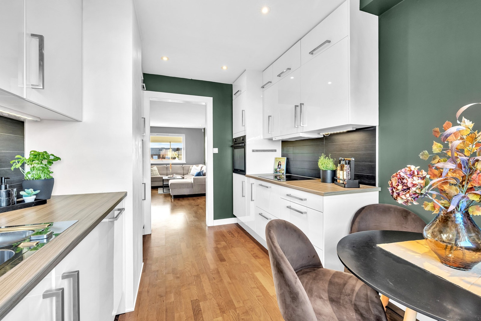 Et velutstyrt kjøkken med integrerte hvitevarer, inkludert kjøleskap med fryser, oppvaskmaskin, stekeovn og platetopp. Galleribilde