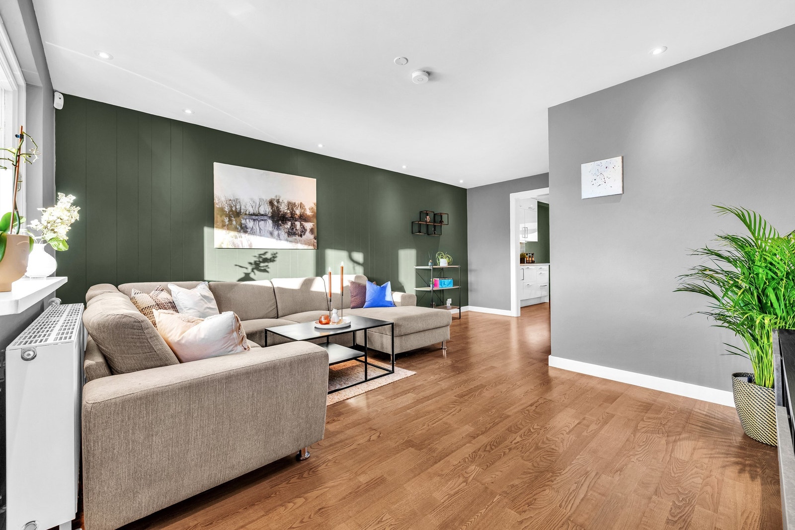 Stuen har en kontrastvegg i en moderne grønnfarge. Galleribilde