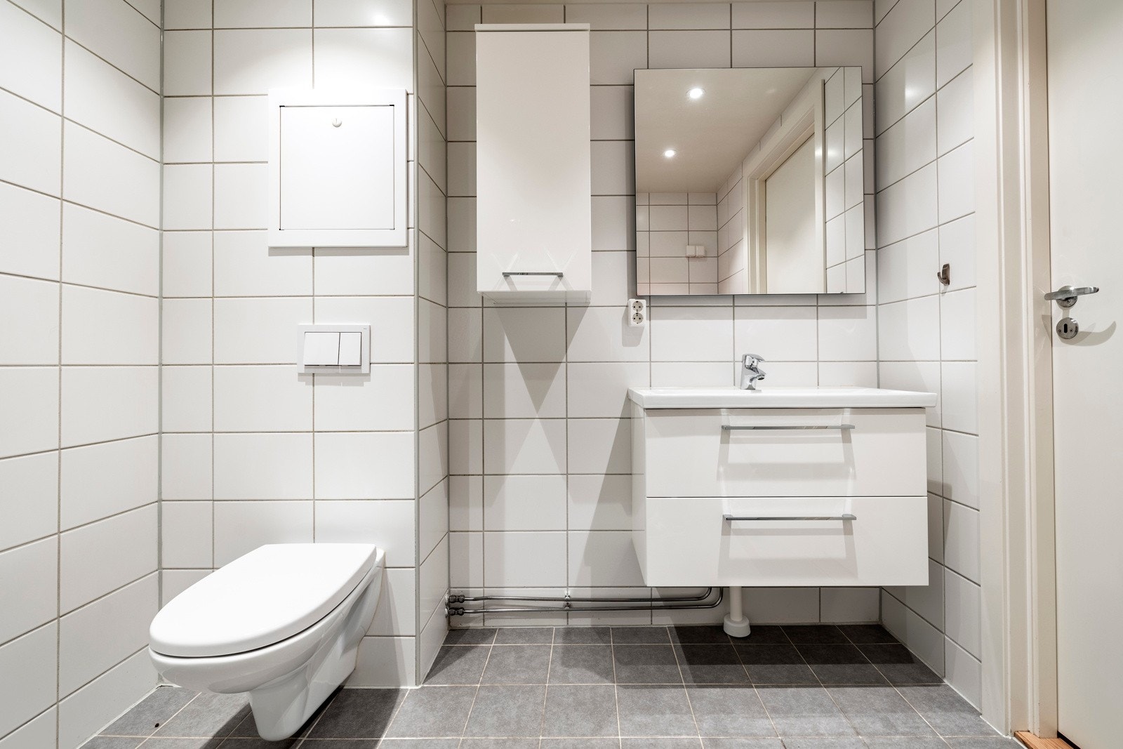 Rommet er innredet med nedfelt servant, veggmontert toalett og dusjhjørne. Galleribilde