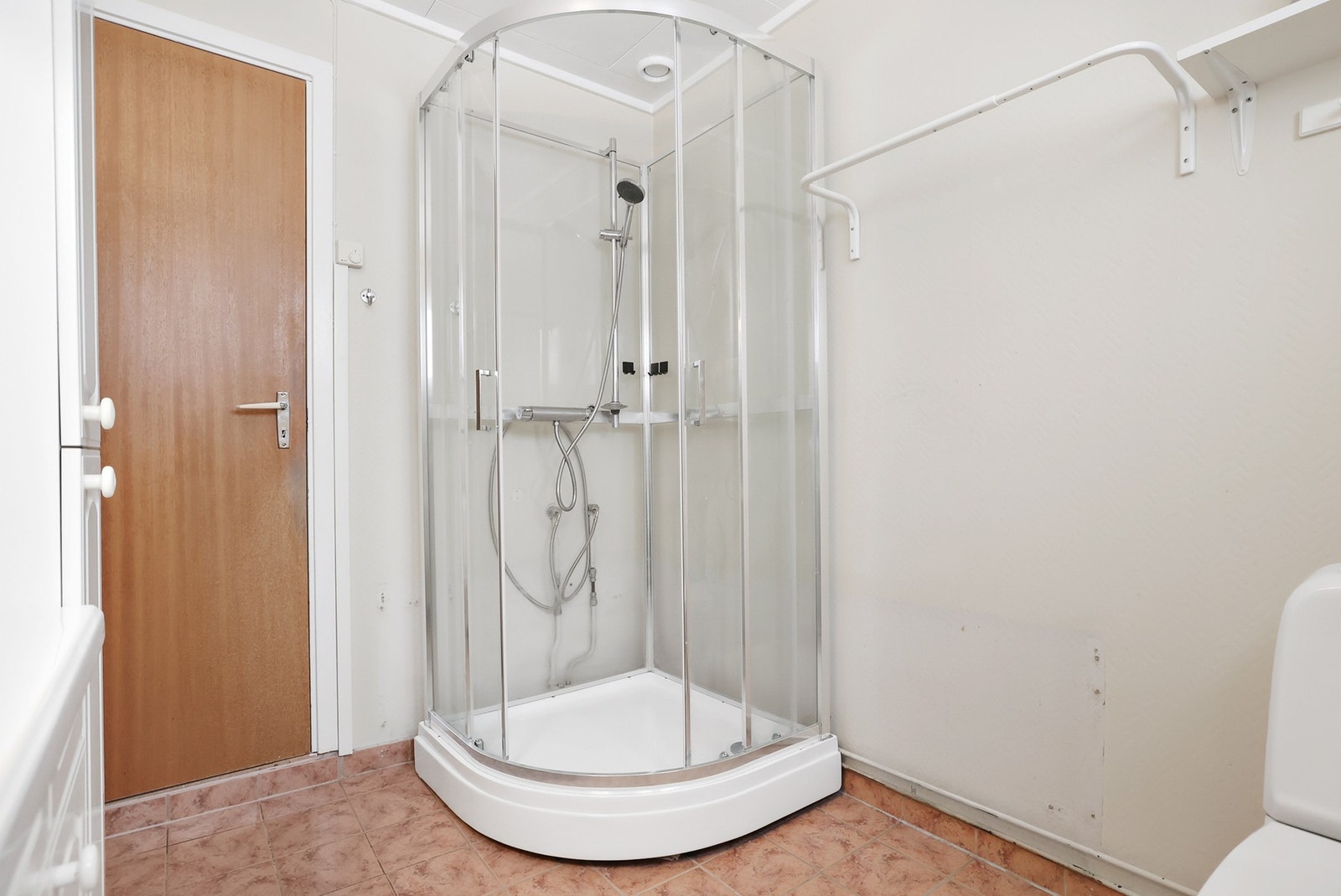 Det er dusjkabinett med dusjarmatur og gode oppbevsringsmuligheter i innredning og på veggmontert hylle. Galleribilde