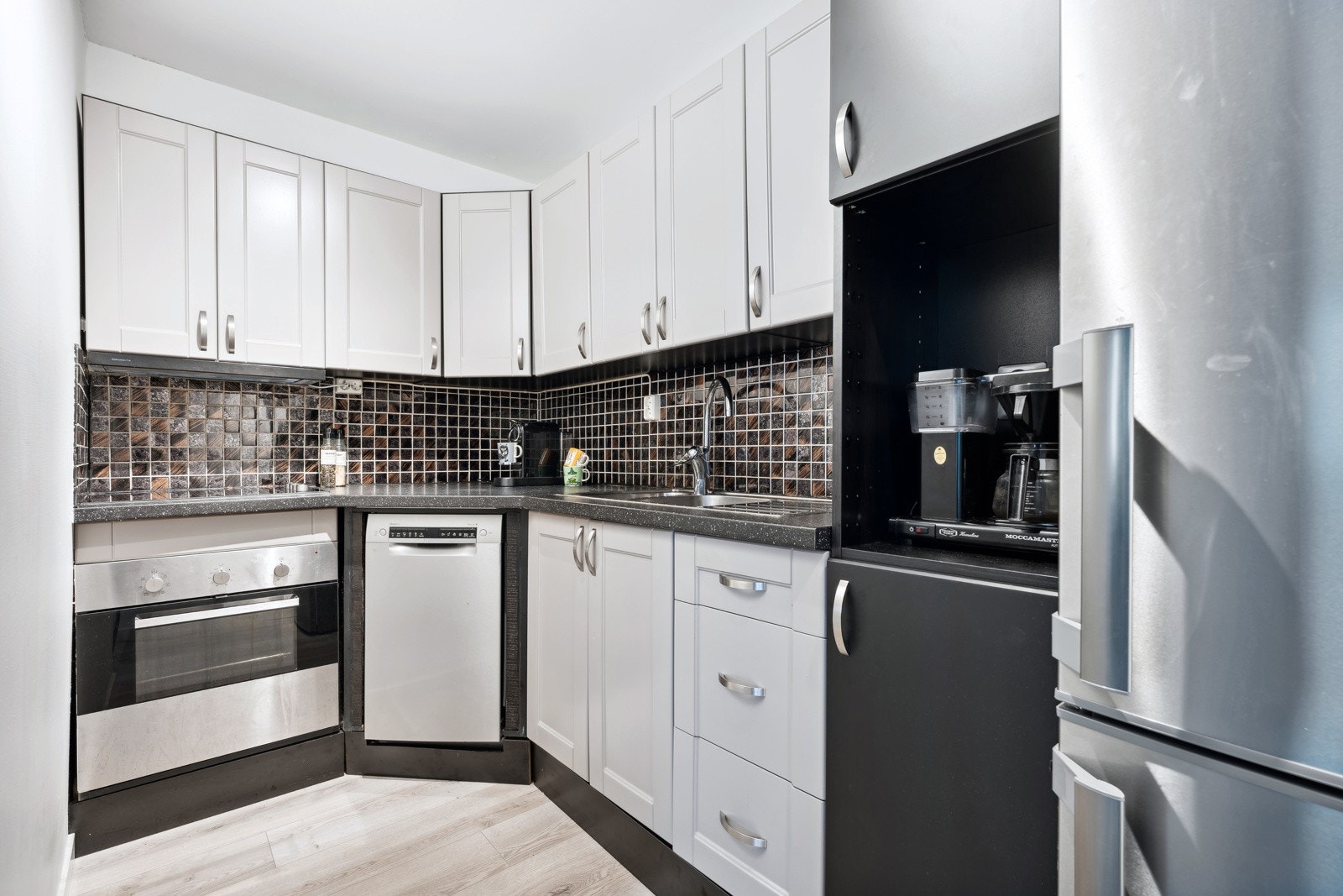 Leilighetens utforming gir et fint skille mellom stue og kjøkken. Galleribilde