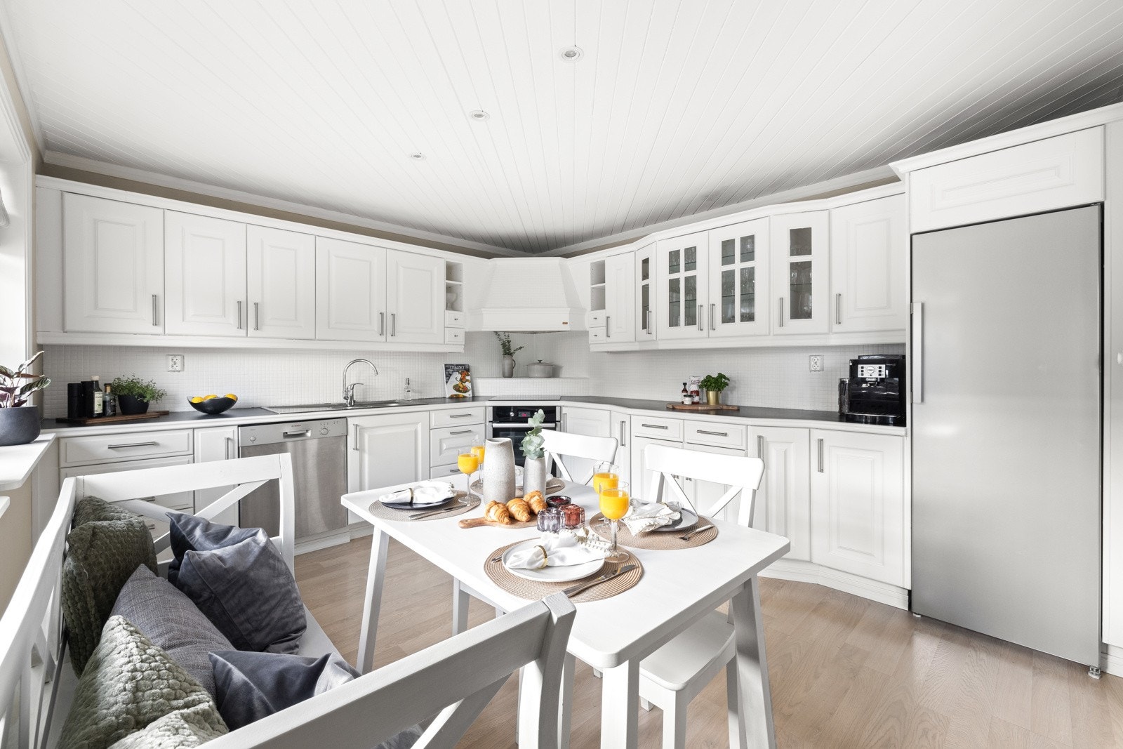 Den hvite innredningen har profilerte fronter og toppes med en slitesterk benkeplate i mørk laminat. Galleribilde