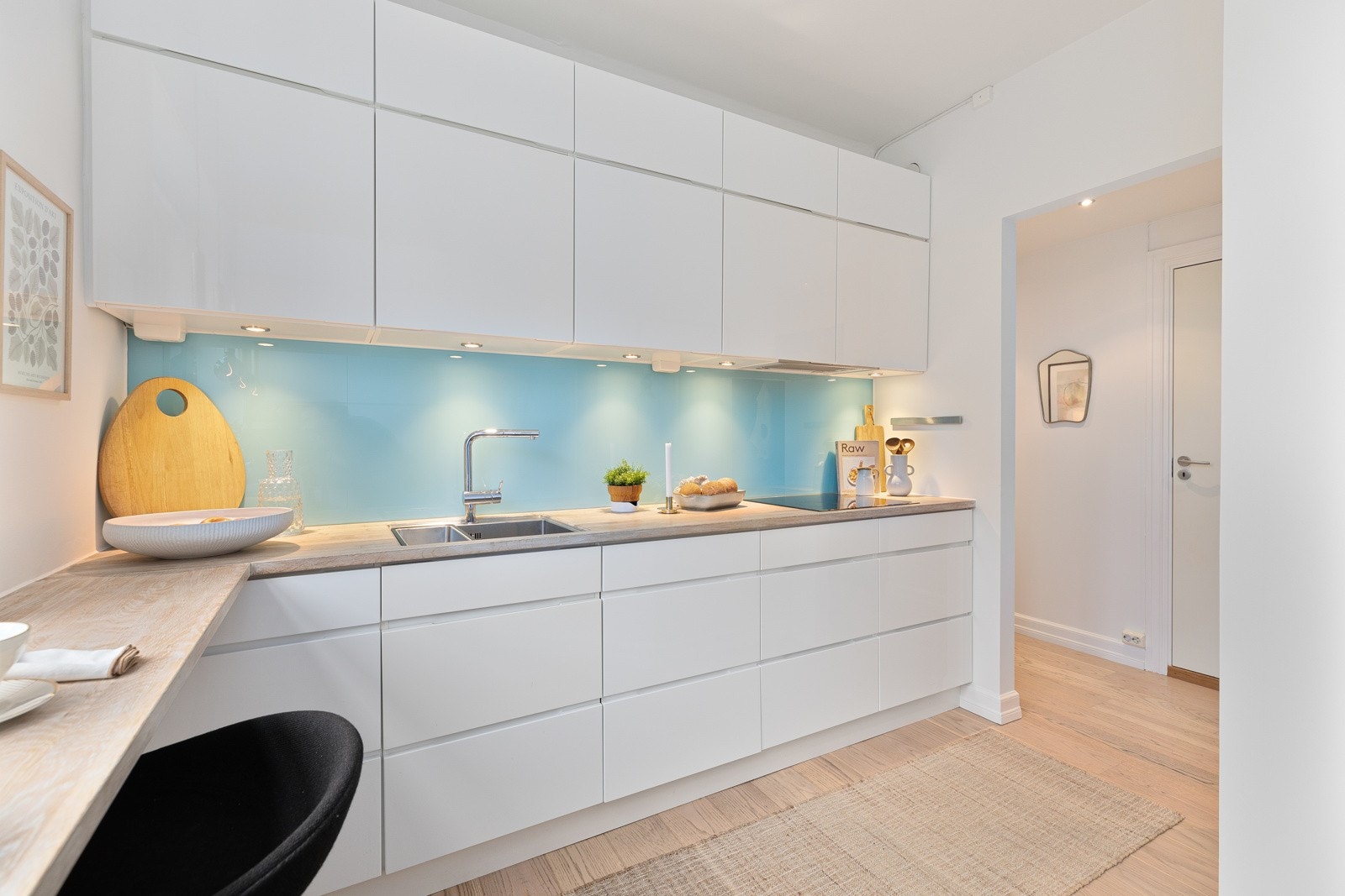 Innredning med glatte, høyglans fronter og heltre benkeplate med planlimt kum i rustfritt stål Galleribilde