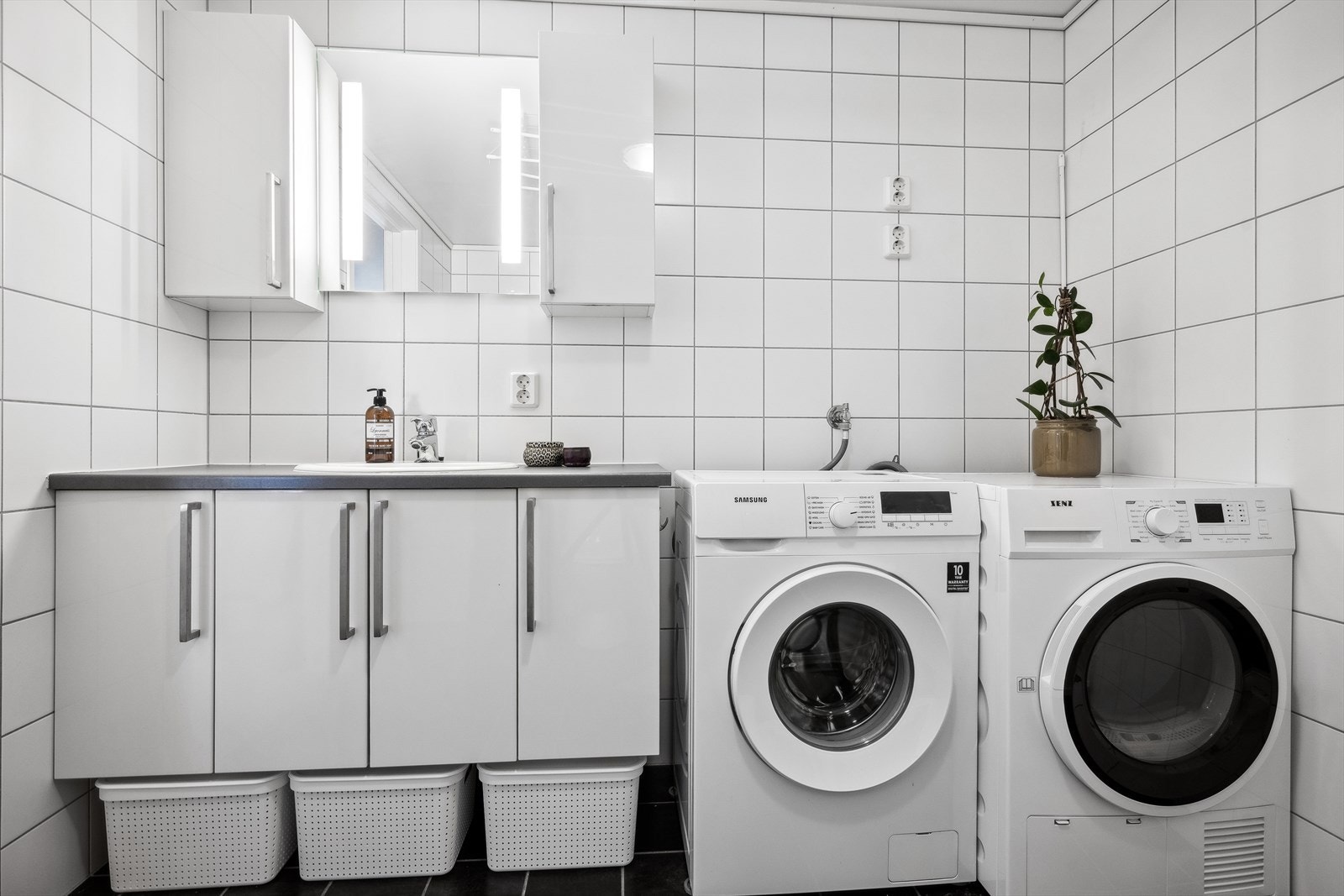 Badet har innredning med nedfelt servant, toalett, dusjkabinett og opplegg for vaskemaskin. Galleribilde