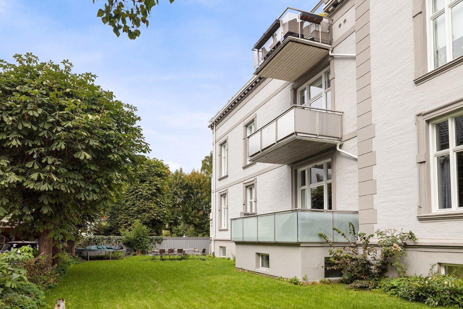 Leiligheten sett nedenifra hyggelig, felles hage. Galleribilde