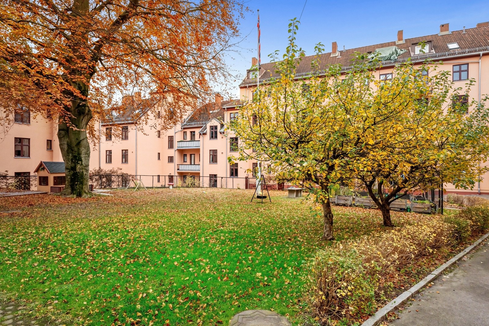 Borettslaget har en nydelig felles bakgård med plen, hellelagte internveier og lekeplasser. Galleribilde