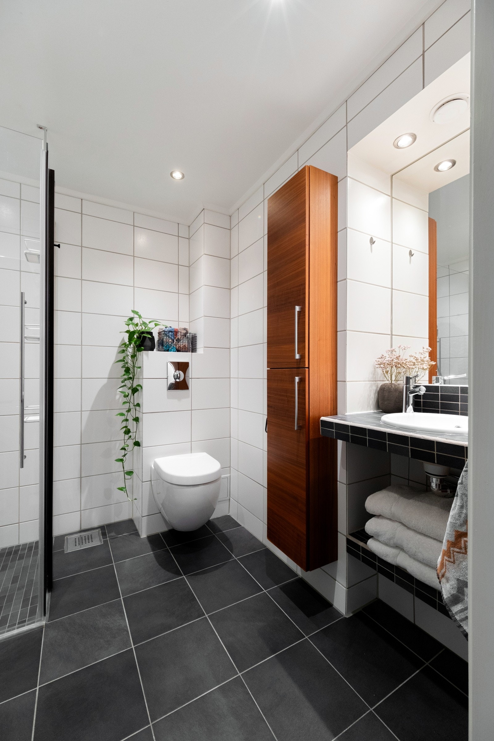 Det er innredet med servant, høyskap på vegg, speil med belysning, glassvegg mot dusjsonen og vegghengt toalett. I gulvene er det lune varmekabler og downlights i tak. Galleribilde