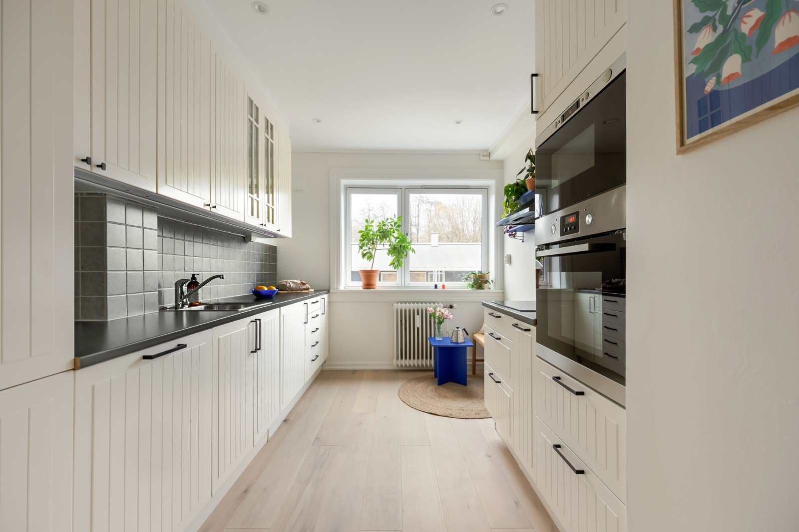 Leiligheten har et innholdsrikt kjøkken som ligger separat fra stuen. Det har lyse fronter og grå benkeplate i laminat. Galleribilde