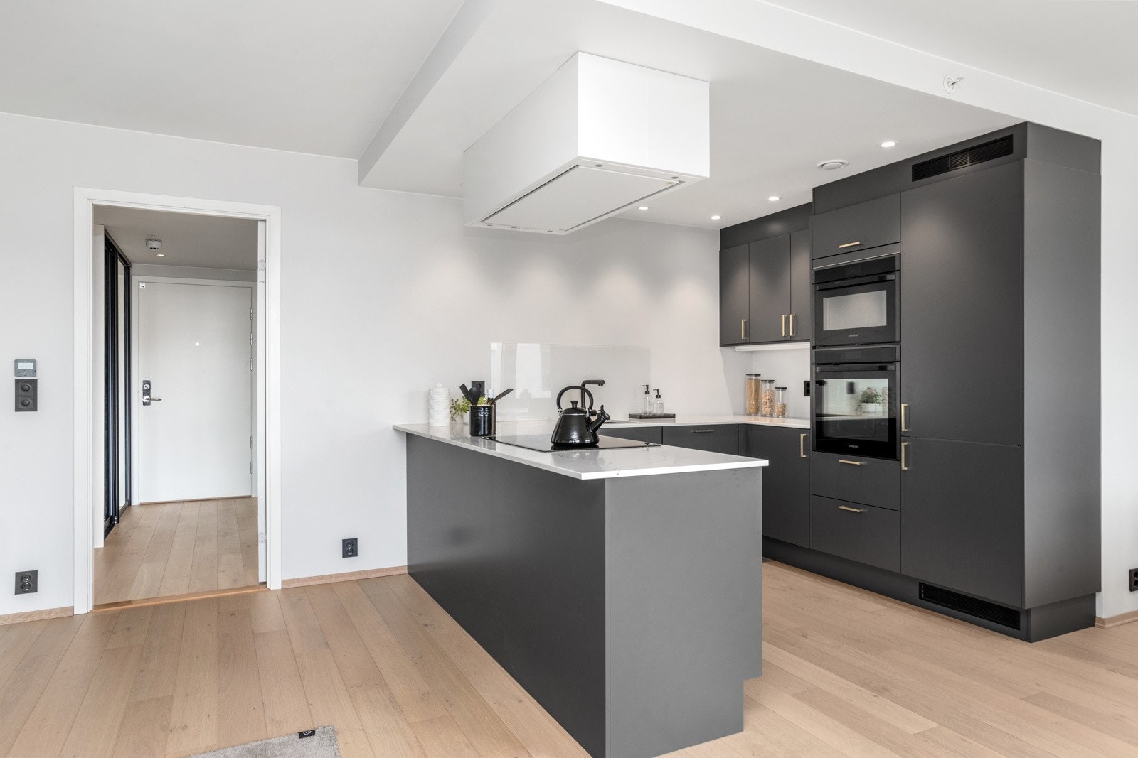 Elegant kjøkkeninnredning med slette fronter og lekker benkeplate av solid kompositt Galleribilde