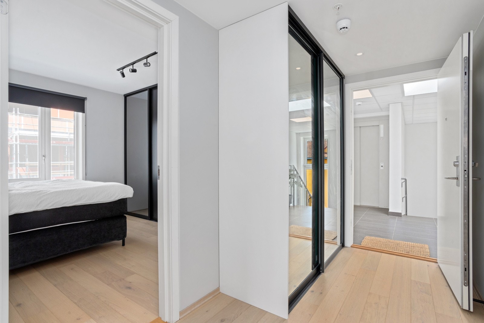 Innbydende og lys entré gir et umiddelbart godt førsteinntrykk av denne lekre leiligheten. I gangen er det satt inn en sort skyvedørsgarderobe med speil, som gjør det enkelt å rydde sko og jakker ut av syne Galleribilde