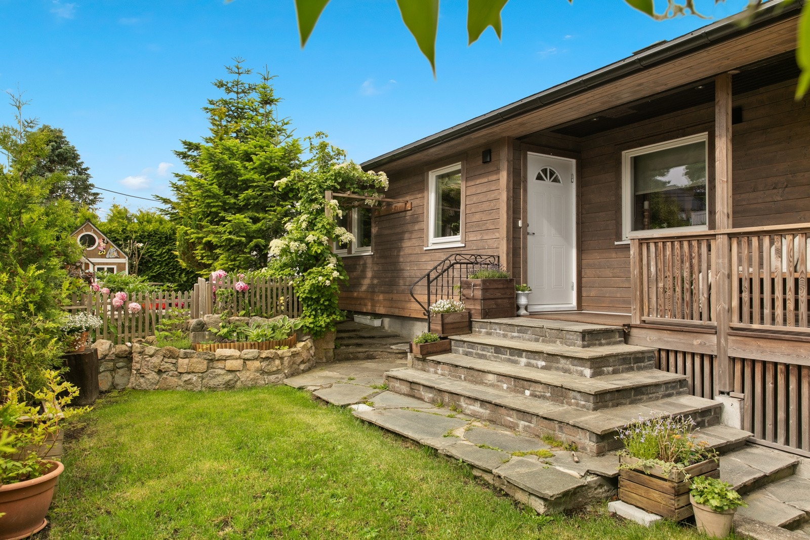 Huser har en spennende tomt med flere fine uteplasser. Det er både sol og utsikt! Galleribilde