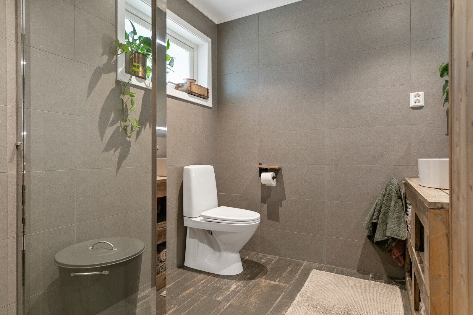 Badet har innredning med speil, dusj og wc Galleribilde