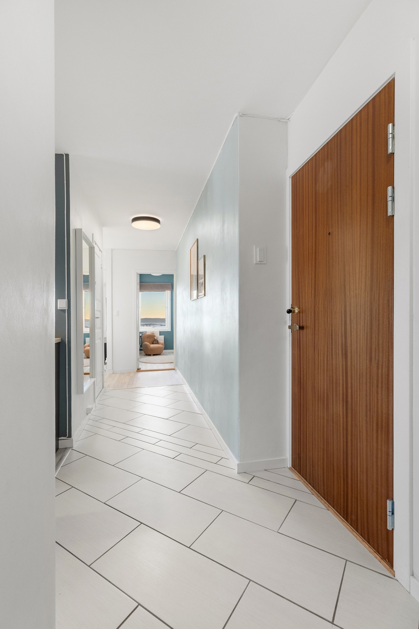 Entréen har fliser på gulv og lysmalte overflater. Galleribilde