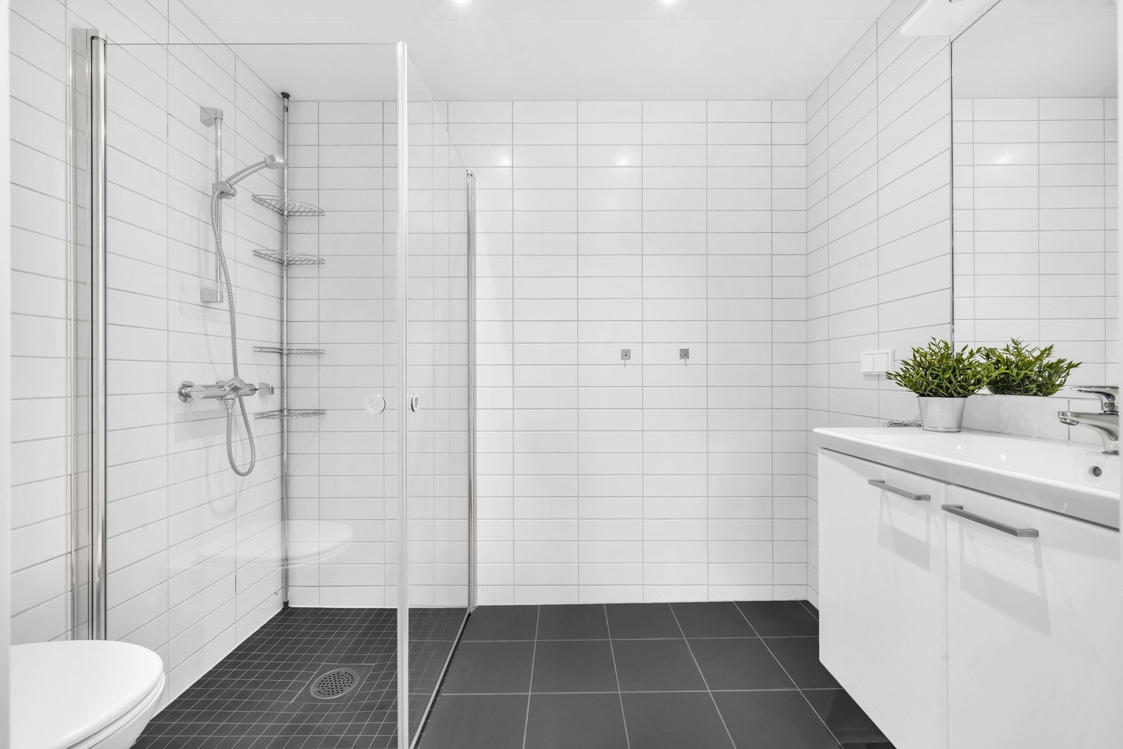 Stort flislagt bad med opplegg for vaskemaskin Galleribilde