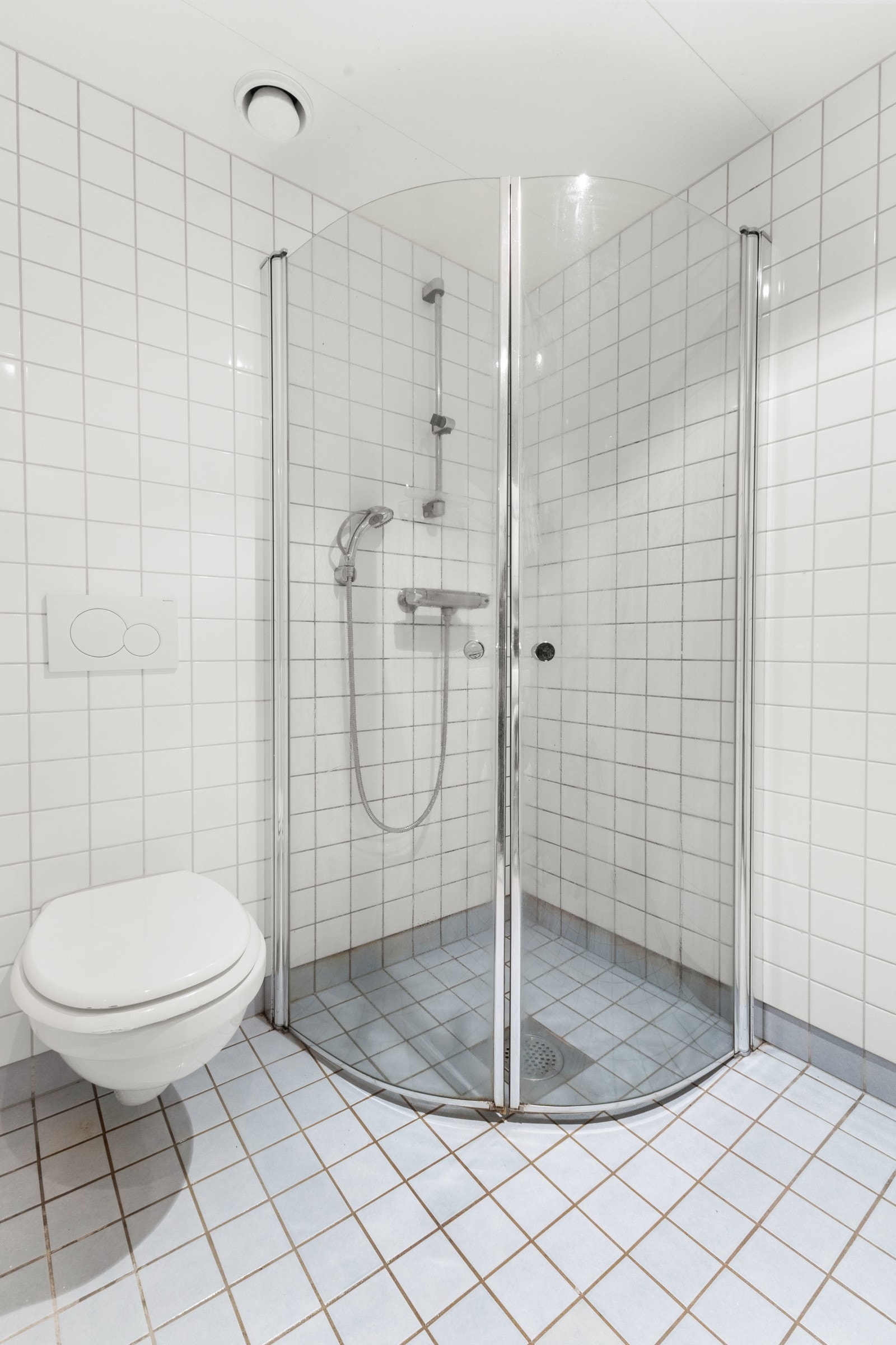 Innredningen består av servant, speil med belysning, veggfestet klosett, benkeskap med glatte fronter og dusj på gulv med herdet glass. Det er opplegg for vaskemaskin på badet. Galleribilde