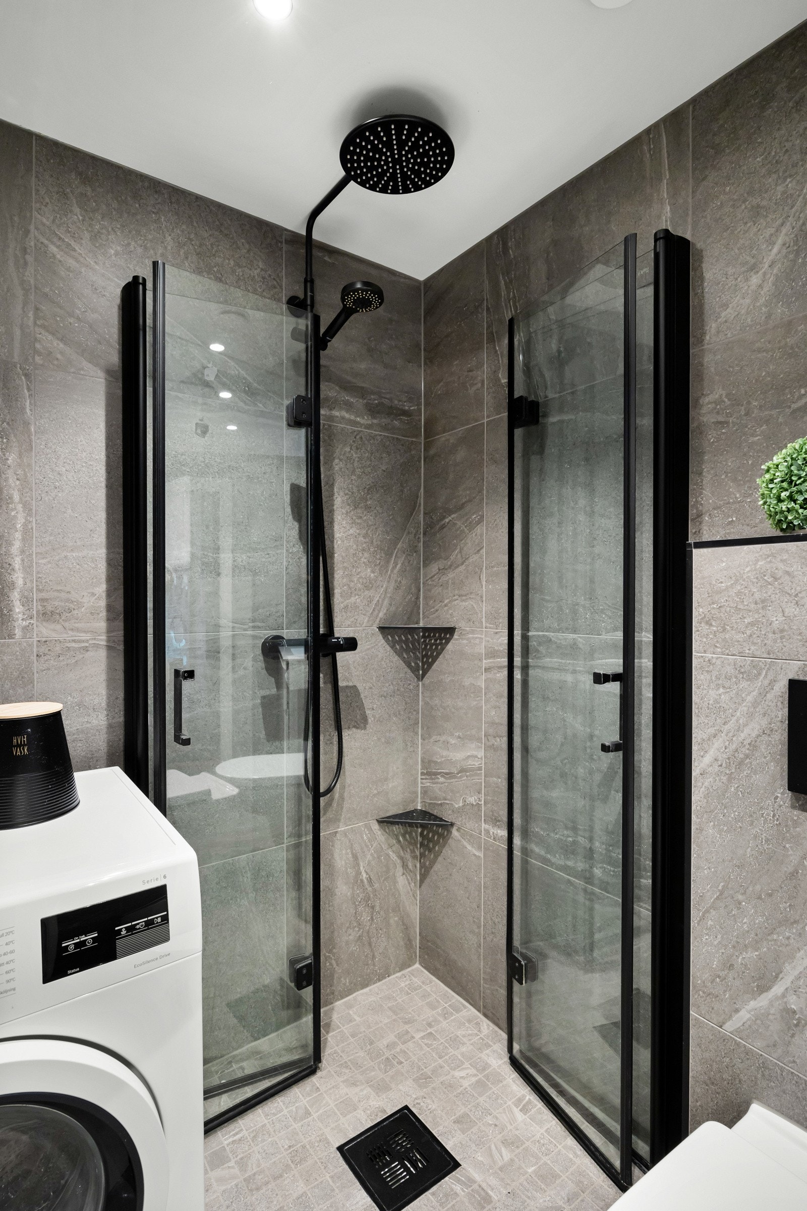 Dusjhjørne med innfellbare glassdører og dusjarmatur tilkoblet hånddusj samt regndusj. Galleribilde