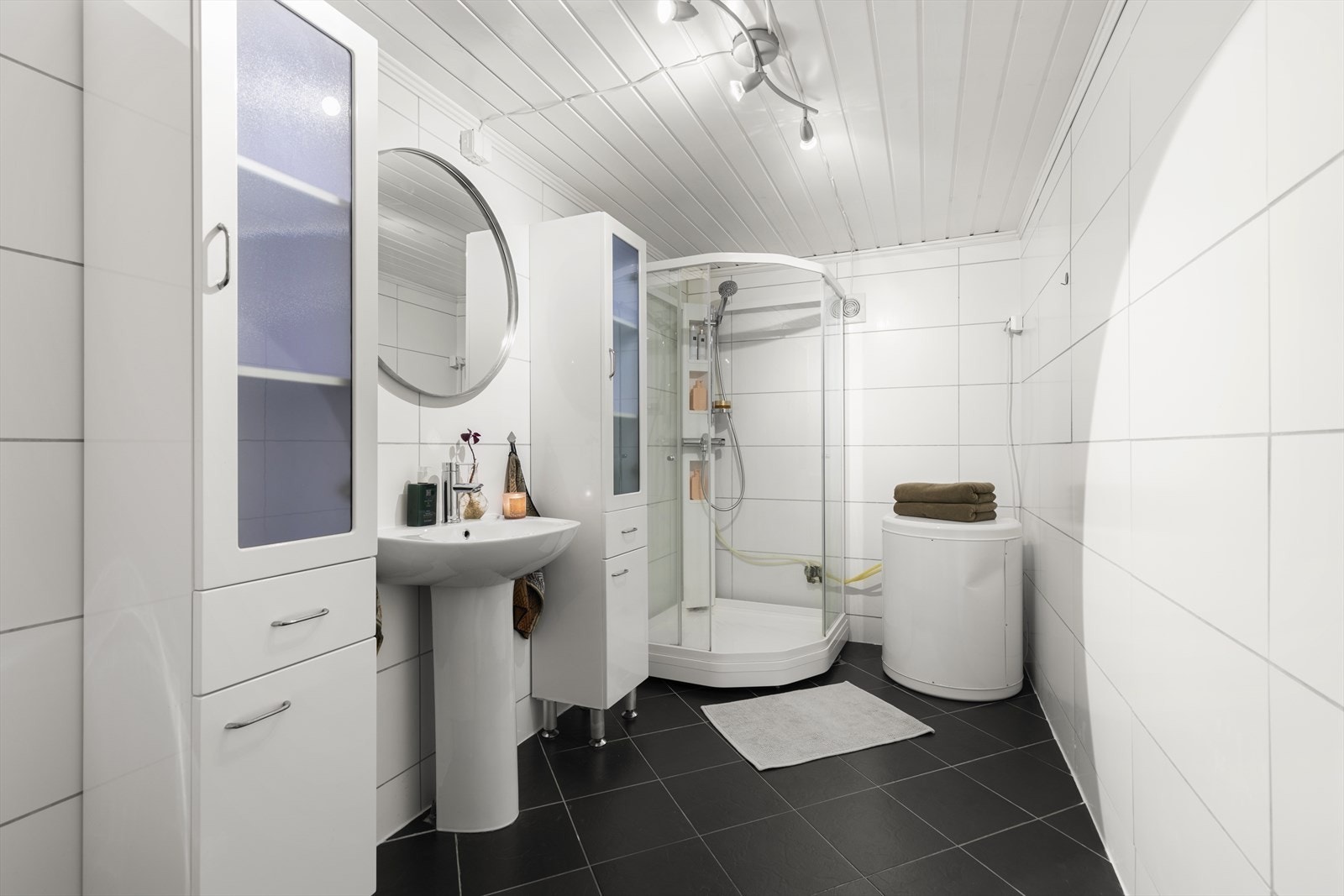 Badet i underetasjen er flislagt og har servant, veggmontert toalett og dusjkabinett. I byggetegningene fra 2008 er badet omtalt som bod. Galleribilde