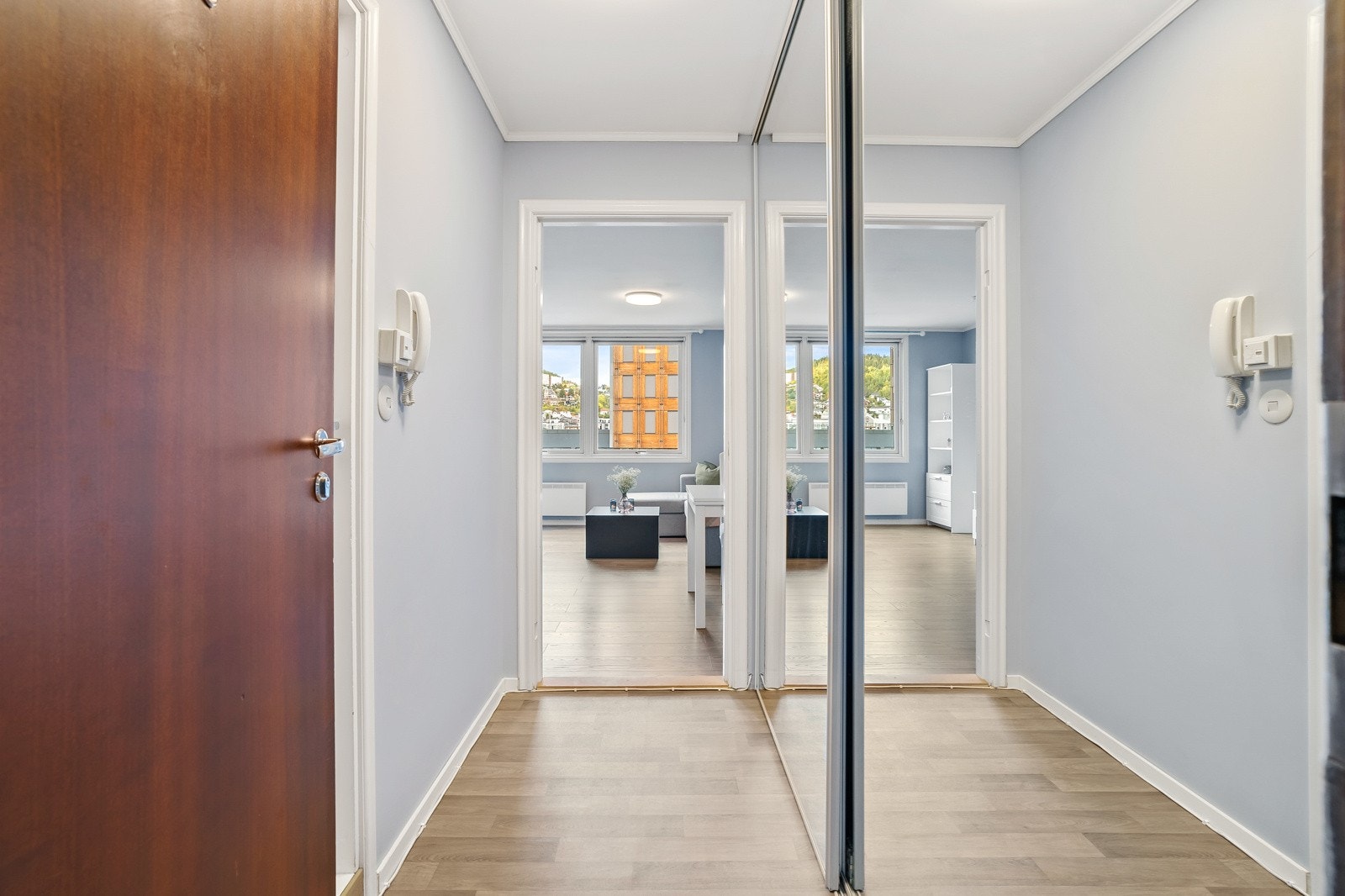 Lys entré med stor skyvedørsgarderobe med speilfronter. Galleribilde