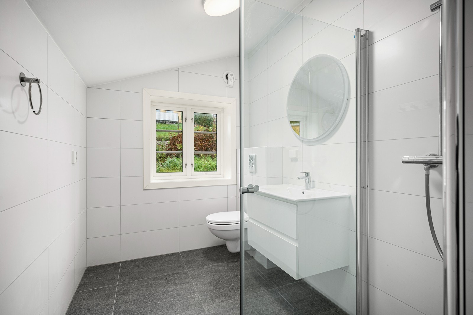 Pent og delikat baderom som er flislagt på gulv og vegger. Fargevalget er i moderne stil. Galleribilde