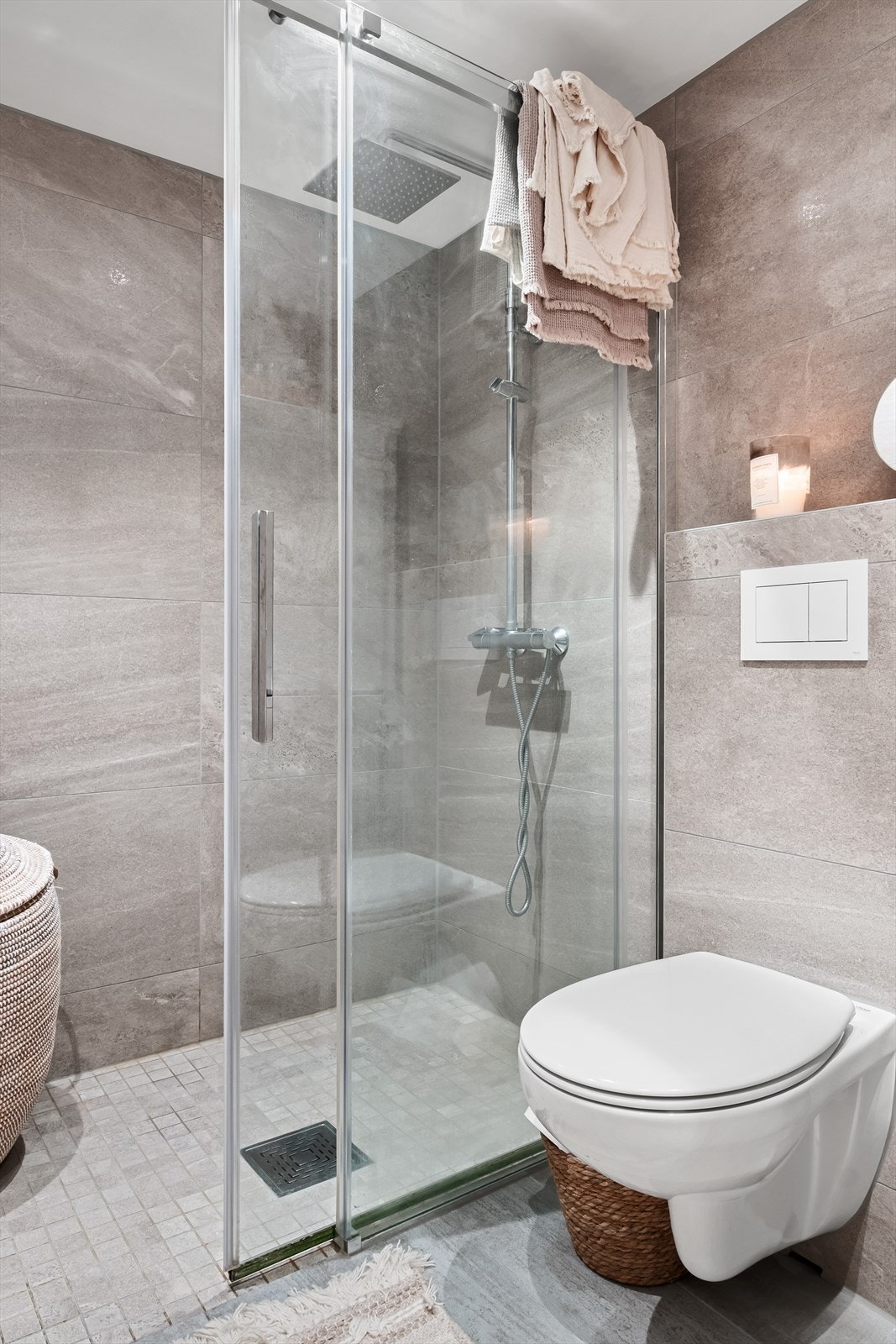Badet er innredet med vegghengt toalett, dusjhjørne, servantskap med blandebatteri og opplegg for vaskemaskin. Galleribilde