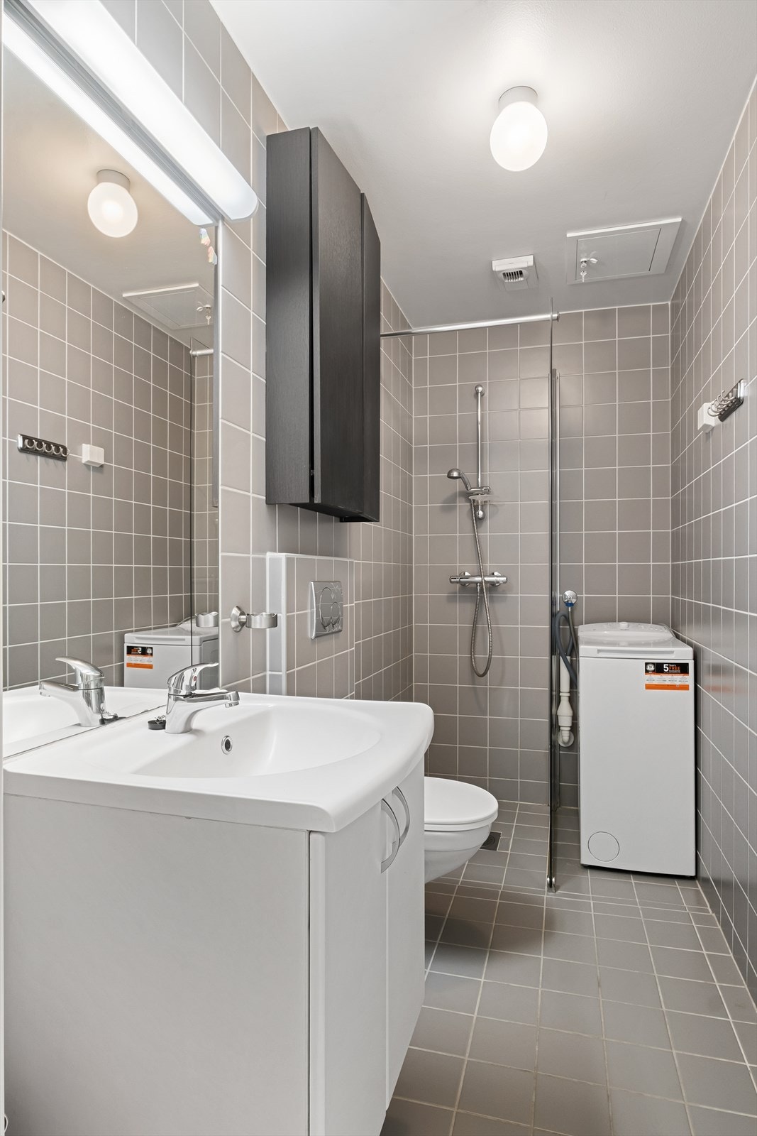 Flislagt bad med dusjhjørne og opplegg for vaskemaskin/tørketrommel Galleribilde