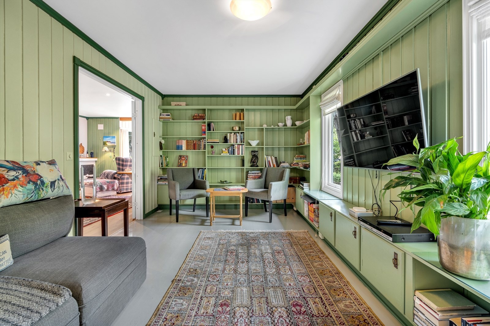 Flott bibliotek/tv-stue med skredderbygget innredning Galleribilde