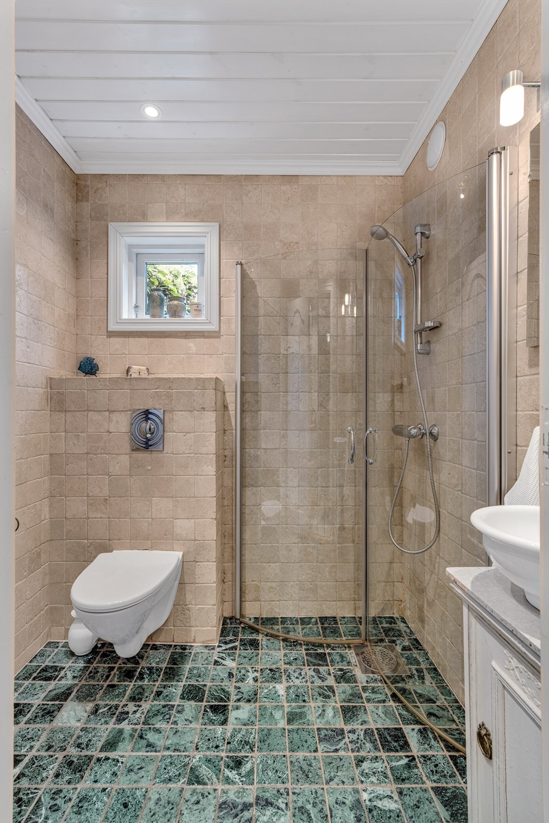 Pent flislagt bad fra 2006 med vegghengt klosett, gulvvarme, dusj og servant med underskap Galleribilde