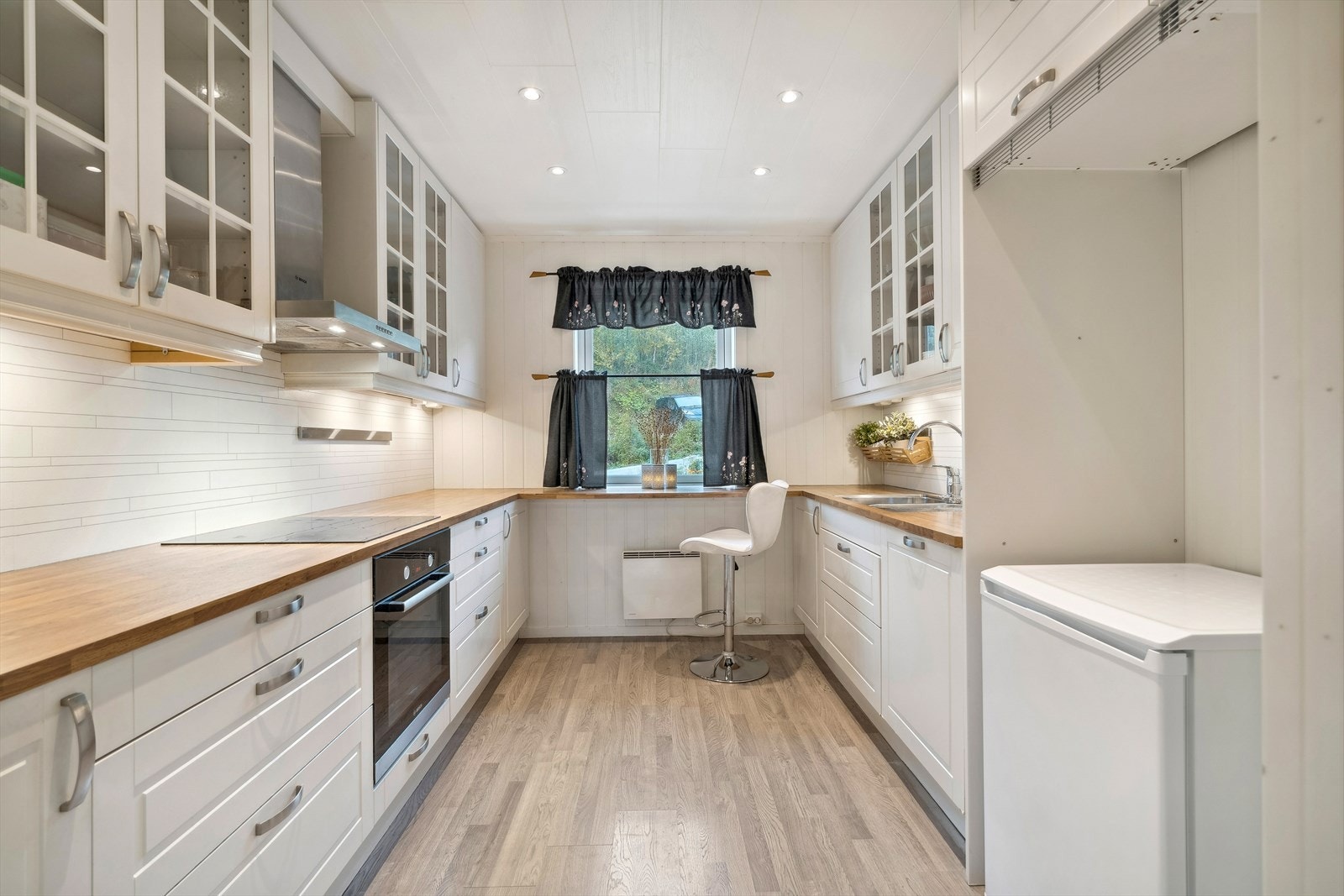 Innholdsrikt kjøkken med mye skap og benkeplass. Galleribilde