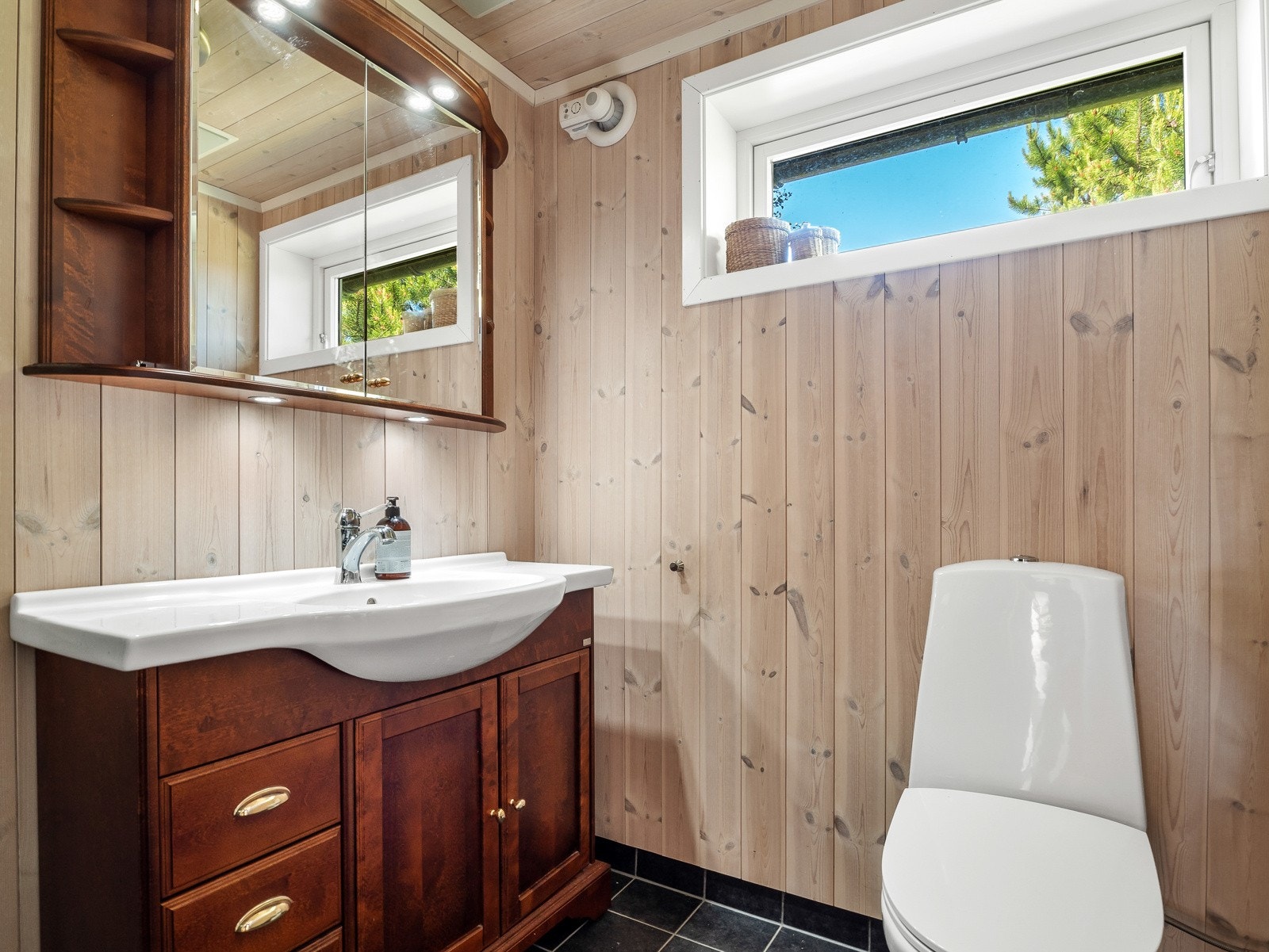 Baderommet har mørkere baderomsinnredning og dusjkabinett med sotede vegger Galleribilde