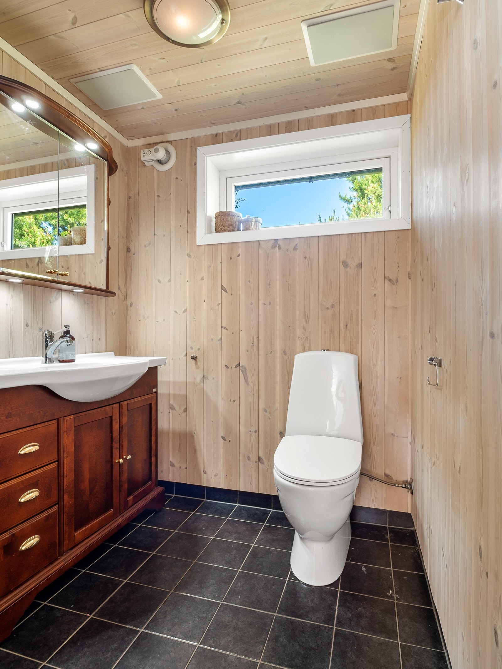 Det er fliser med varmekabler på gulv og panel på vegger og i tak Galleribilde