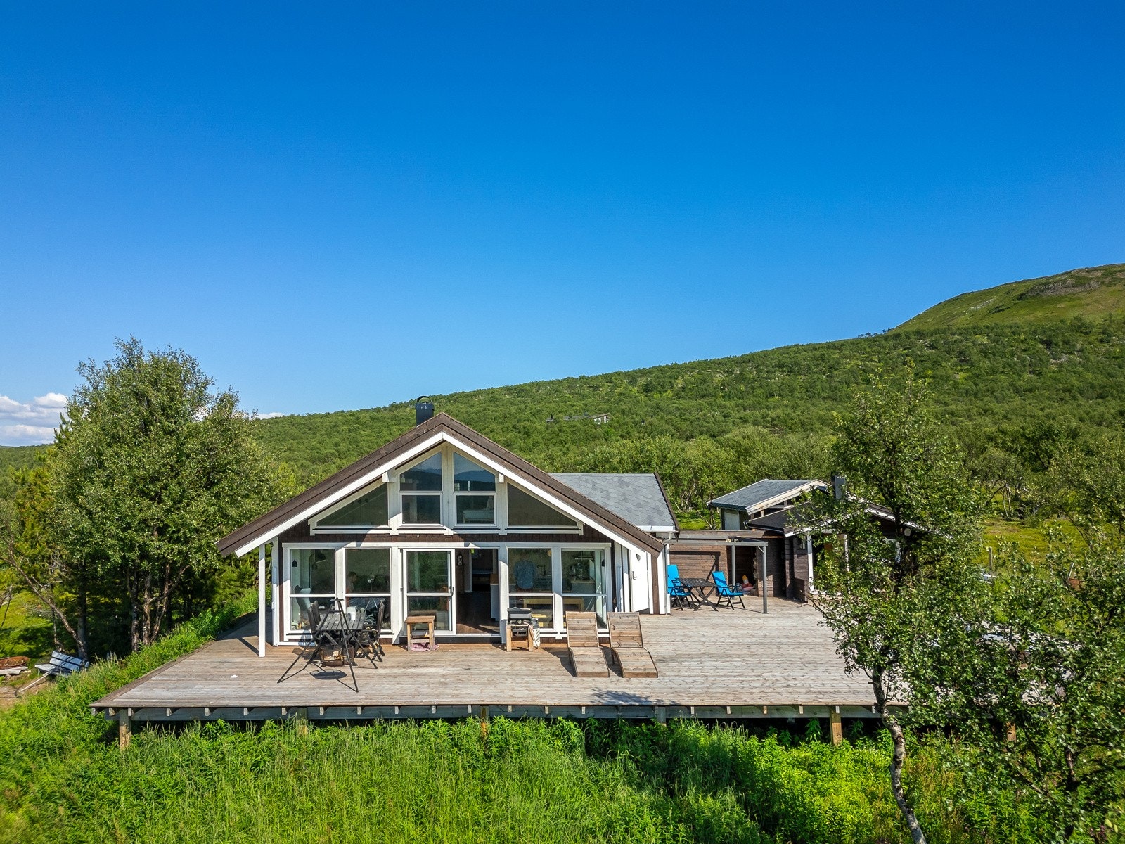 Det er en meget stor, solrik platting/terrasse med plass til flere sitteområder, slik at man kan plassere seg etter vær og vind Galleribilde